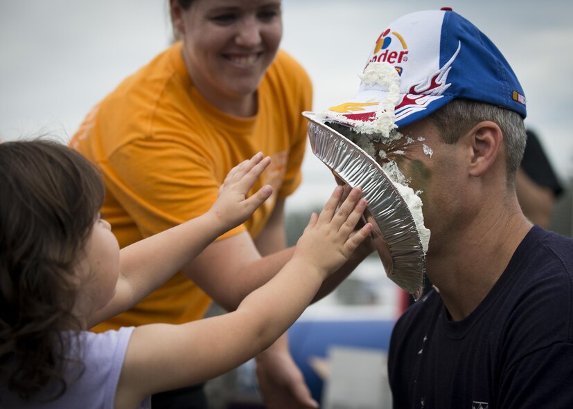 Peyton Roszkowski throws a pie in Col. Robert Bruckner, 919th Special Operations Wing Vice commander during the Duke Field Wing Day event Nov. 7.  The 919th SOW sets aside a special day each year to show appreciation for its reservists and their family members. Events included music, sports, children’s games, etc. (U.S. Air Force photo/Tech. Sgt. Jasmin Taylor)