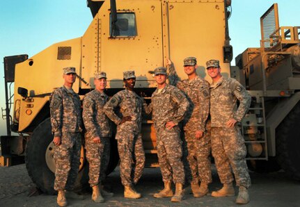 North Carolina Army National Guard Soldiers of the 1452nd Transportation Company pose for a group photo in front of an M-1070A1 Heavy Equipment Transporter in Kuwait, Dec. 19, 2011, just one day after their convoy was the last to depart Iraq.