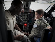 Tech. Sgt. Sedrick Dottin, 919th Special Operations Aircraft Maintenance Squadron, and Kekoa Lee tours a C-145 during the Duke Field Operation Hero event Nov. 7. The event was a mock deployment exercise for 919th Special Operations Wing children. The exercise started with the kids receiving orders before deploying to the 919th Special Operations Logistics Readiness Squadron building. The “little deployers” were issued fake military ID cards, dog tags, and immunizations. (U.S. Air Force photo/ Tech. Sgt. Jasmin Taylor)