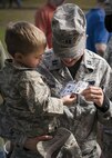 Matthew compares his id to his mother’s, Capt. Susan Frank, 919th Special Operation Logistics Readiness Squadron, during the Duke Field Operation Hero event Nov. 7. The event was a mock deployment exercise for 919th Special Operations Wing children. The exercise started with the kids receiving orders before deploying to the 919th SOLRS building. The “little deployers” were issued fake military ID cards, dog tags, and immunizations. (U.S. Air Force photo/ Tech. Sgt. Jasmin Taylor)