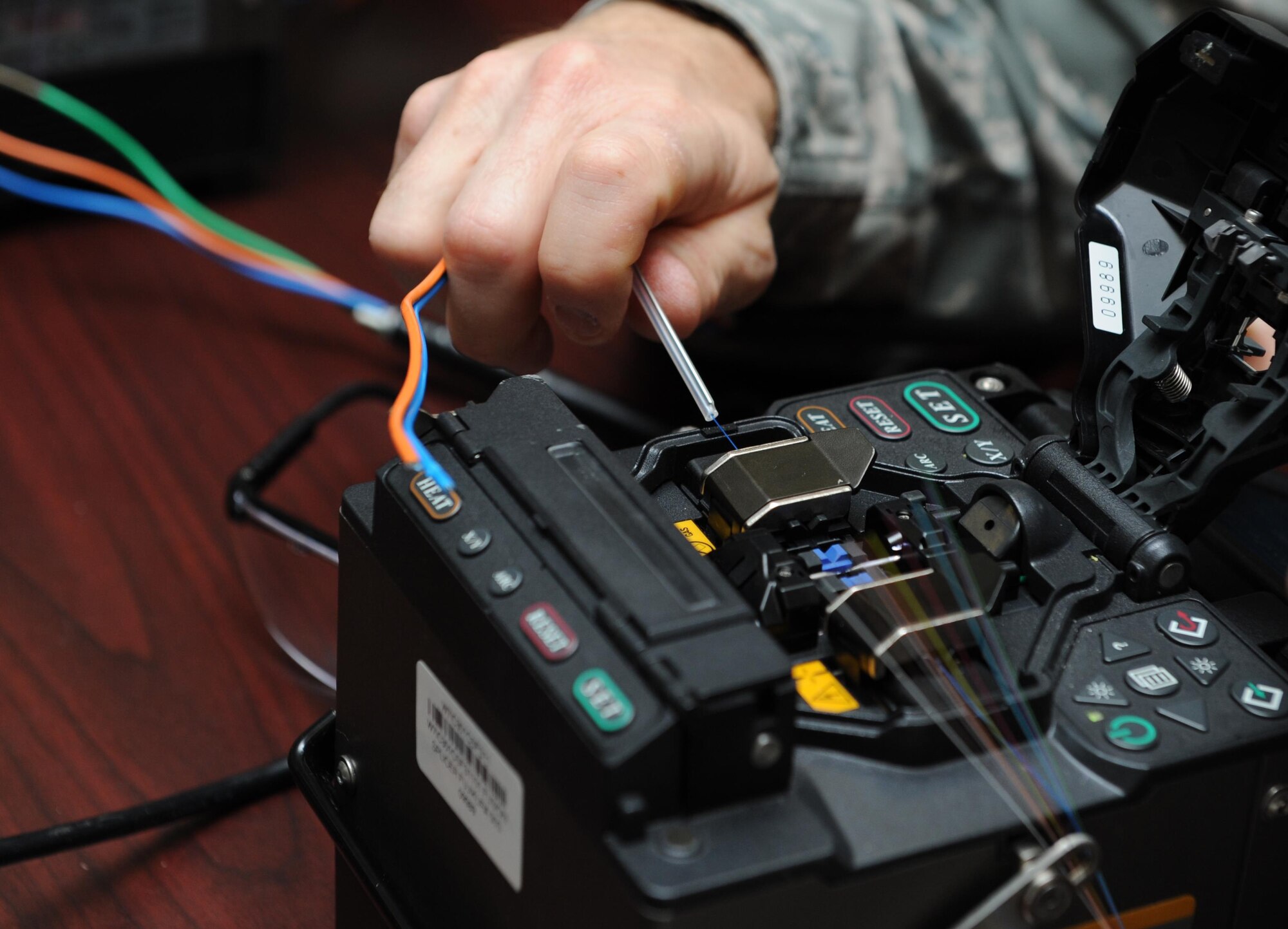 Col. Frank Amodeo, 403rd Wing commander, attempts to splice a fiber optic cable during the 85th EIS open house for base leadership at Maltby Hall Nov. 3, 2015, Keesler Air Force Base, Miss. The open house also included a mission brief, tower rescue demonstration, radiation hazards tour and an infrared camera demonstration. (U.S. Air Force photo by Kemberly Groue)
