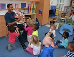 Associate Teacher Derrhyl Duncan reads a story to children at the Bettye Ackerman-Cobb Child Development Center on Defense Supply Center Richmond, Virginia, Nov. 4, 2015.