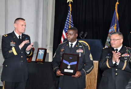 New York Army National Guard Command Sgt. Major Anthony McLean accepts the New York State Medal of Valor on behalf of Sgt. Henry Johnson during a ceremony marking the display of a Medal of Honor posthumously awarded to Johnson for his World War I actions, on Nov. 9, 2015, at the New York State Capitol in Albany. Also pictured are Maj. Gen. Patrick Murphy ( right) the adjutant general of New York and Col. Dave Martinez, the commander of the 369th Sustainment Brigade. 