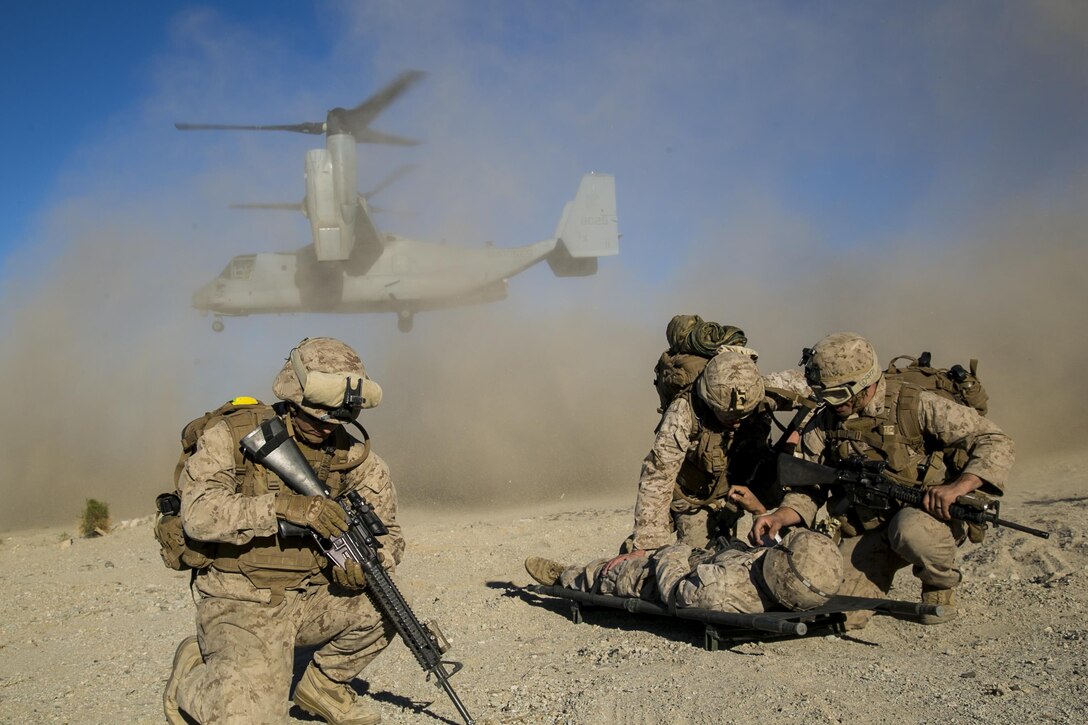 Marines shield a simulated casualty from the debris of a U.S. Marine Corps MV-22 Osprey during composite training on Marine Corps Air Ground Combat Center Twentynine Palms, Calif., Oct. 30, 2015. U.S. Marine Corps photo by Cpl. Briauna Birl