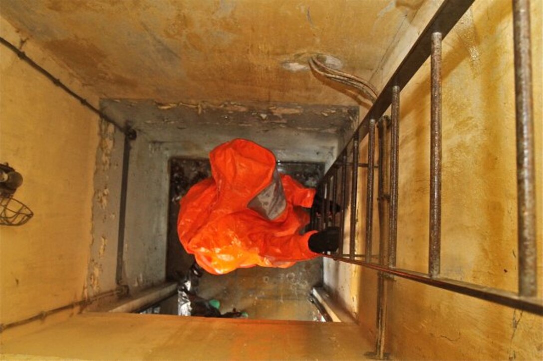 RELEGEM, Belgium - During CBRN Week 2015, U.S. Army Reserve Staff Sgt. Adrian Sherfield climbs into a debris-filled structure to survey for Chemical, Biological, Nuclear and Radiological hazards. (Photo by Staff. Sgt. Rick Scavetta, 7th Mission Support Command)