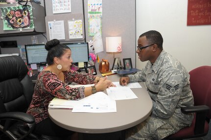 Amanda Jalomo, Joint Base San Antonio-Randolph Education Center education specialist, talks to Senior Airman Princeton Blanchard, Air Force Personnel Center, on reaching his educational goals during the Virtual Education Fair Nov. 4, 2015 at JBSA-Randolph.  Virtual Education Fairs, help students search for schools, meet education career needs, live chat with representatives from participating schools and give financial aid options.  (U.S. Air Force photo by Joel Martinez/Released)