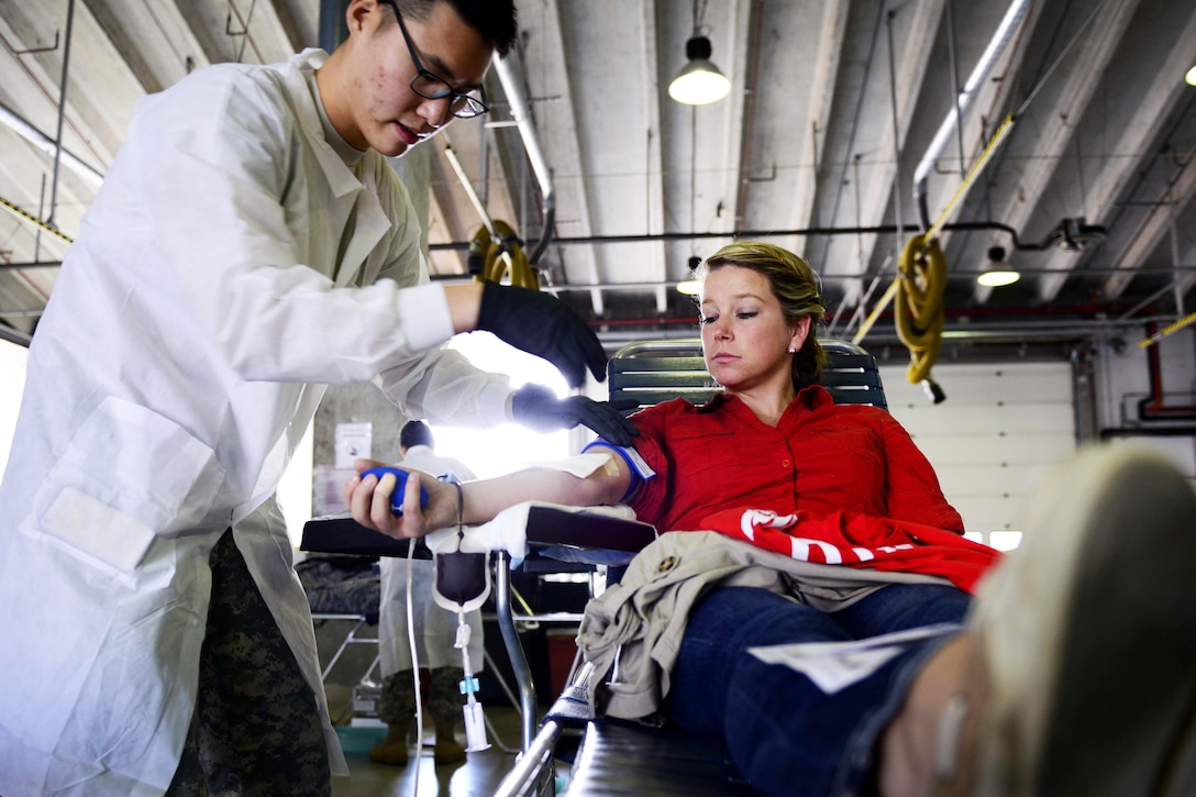 U.S. Army Spc. Hayeon McCurley prepares U.S. Air Force Senior Airman Kimberly Gray to give blood during the Armed Services Blood Program blood drive on Aviano Air Base, Italy. Nov. 9, 2015. Hayeon is a medical laboratory technician at Landstuhl Regional Medical Center and Gray is an investigator with the 31st Security Forces Squadron. U.S. Air Force photo by Senior Airman Areca T. Bell