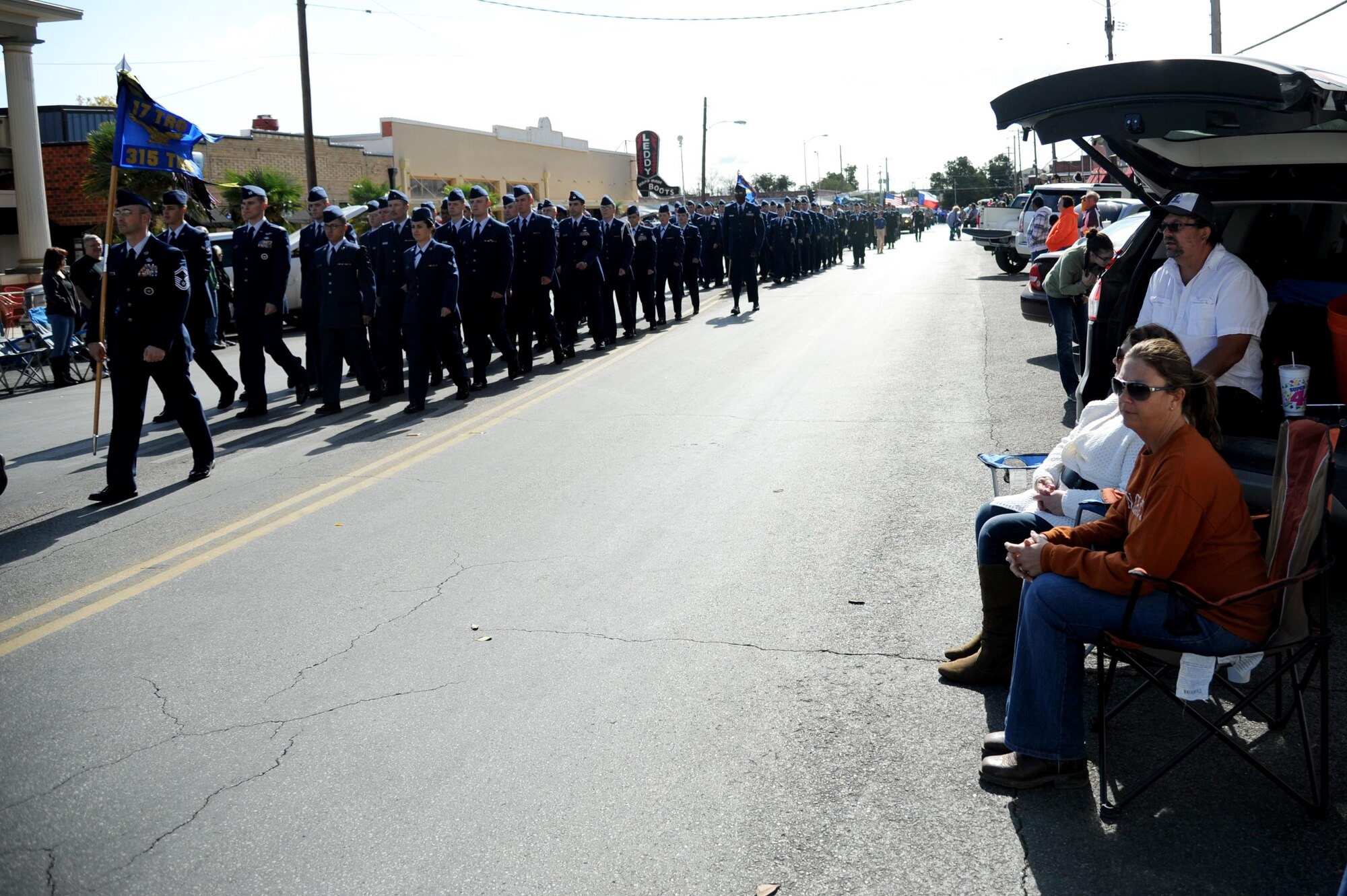 People watch as the 17th Training Group formation passes them at the Veterans Day Parade in San Angelo, Texas, Nov. 7, 2015. Soldiers, Marines, Sailors and Airman from Goodfellow Air Force Base and the U.S. Air Force Band of the West from Joint Base San Antonio, Texas, marched in the event. (U.S. Air Force photo by Senior Airman Joshua Edwards/Released)