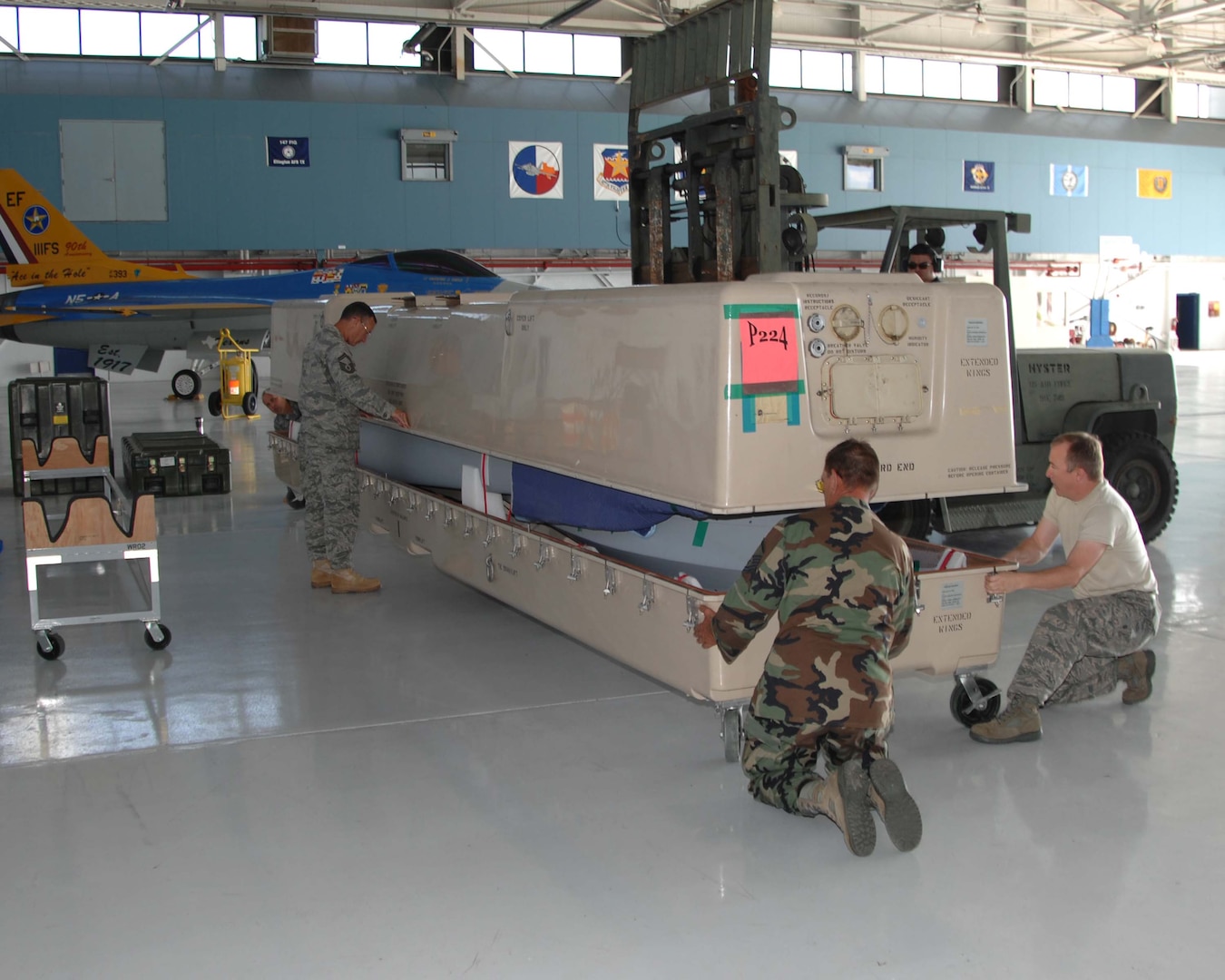 Members of the 147th Reconnaissance Wing Maintenance Group open the crate holding an MQ-1 Predator at Ellington Field Joint Reserve Base in Houston, Aug. 18, 2009. The wing is transitioning from the F-16 to the MQ-1 and this is the first of several Predators that the wing will receive.