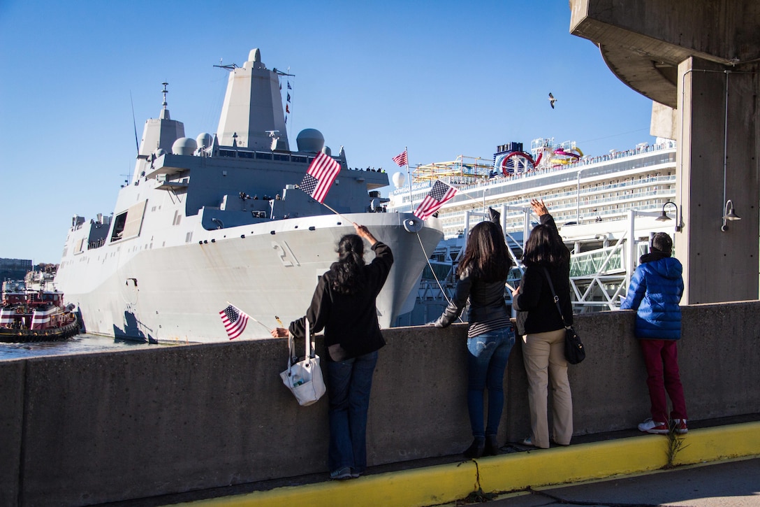 People wave American flags to welcome the USS New York to Manhattan's west side as the ship pulled arrived in New York City, Nov. 8, 2015. U.S. Navy photo by Lt. Matthew A. Stroup