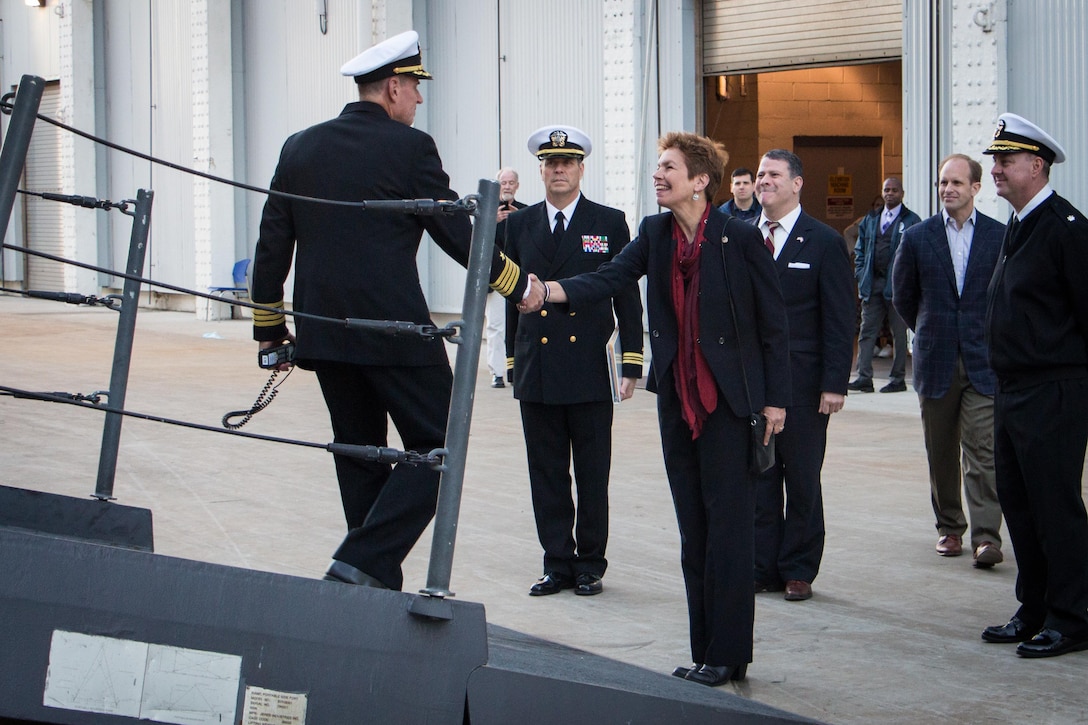 Loree Sutton, center right, commissioner of the Mayor's Office of Veterans Affairs, shakes hands with Navy Capt. Kenneth Coleman, commander of the USS New York, after the ship arrived in New York City, Nov. 8, 2015. U.S. Navy photo by Lt. Matthew A. Stroup