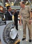 NSWCDD engineer Helmer Flores demonstrates how a shipboard Collective Protection System (CPS) filter housing works while briefing Rear Adm. Brian Antonio, program executive officer for the Littoral Combat Ships program, on the system and its capabilities. NSWCDD CBR Defense engineers designed the shipboard collective protection system to protect Sailors, critical operations, and equipment within selected areas of a ship, or zones, from CBR contamination when the ship is operating in a contaminated environment. Personnel in the protected zone do not need to wear protective clothing or masks which impose heat stress and can impact crew members' performance.