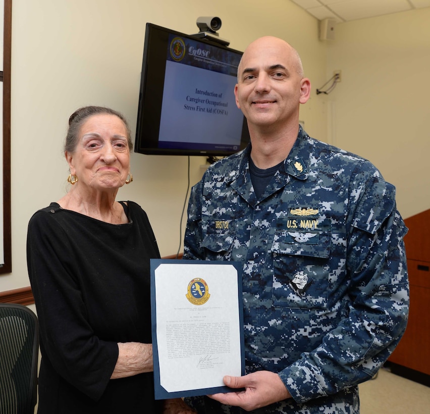 Cmdr. Raymond Bristol, officer-in-charge, Naval Branch Health Clinic Albany, presents Fran Quinn, health benefits advisor, NBHC Albany, with commendations and gifts during a retirement ceremony at the clinic aboard Marine Corps Logistics Base Albany, Nov. 4. Quinn was honored by personnel and well-wishers for her 55 years of federal service, 48 of which were spent at NBHC Albany.