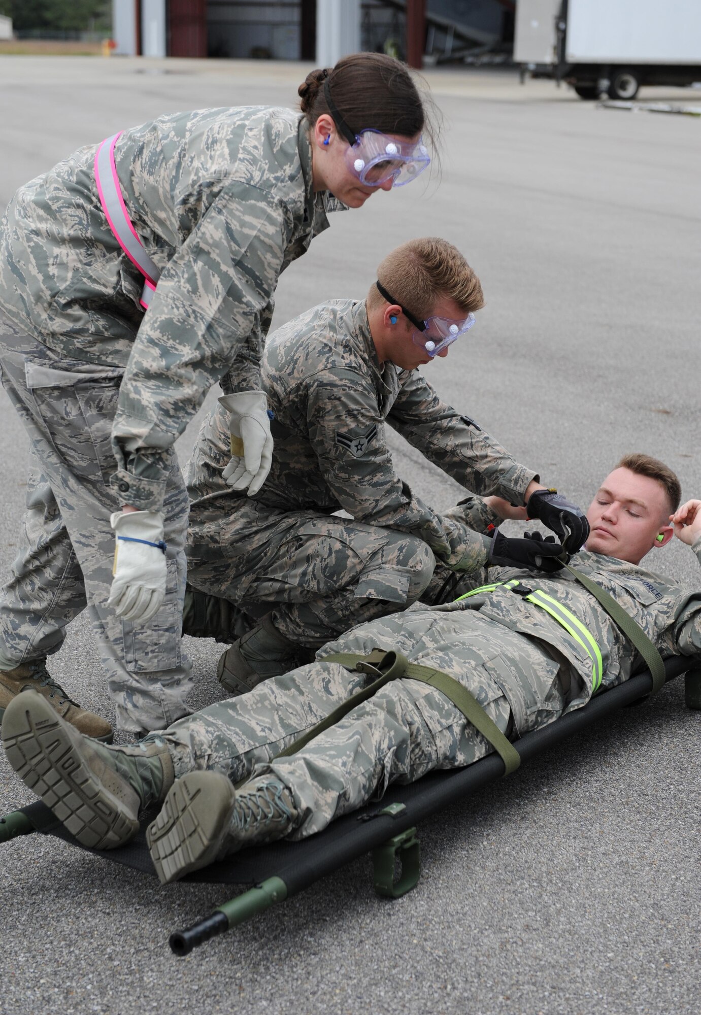 Capt. Katherine Jones, 81st Aerospace Medicine Squadron health clinic physician, and Airman 1st Class Chandler Hudson, 81st AMDS medical technician, secure the stretcher straps on Airman 1st Class Alixandru Inman, 81st AMDS medical technician, Keesler Air Force Base, Miss., during the Mississippi National Guard’s annual Southern Strike training at Stennis International Airport Nov. 5, 2015, Miss. Members of the 81st AMDS assisted with aircraft engine running on- and off-loading. The two-week joint international combat exercise was hosted by the Mississippi National Guard and included service members from both active and reserve components in every branch of the U.S. military service. (U.S. Air Force photo by Kemberly Groue)