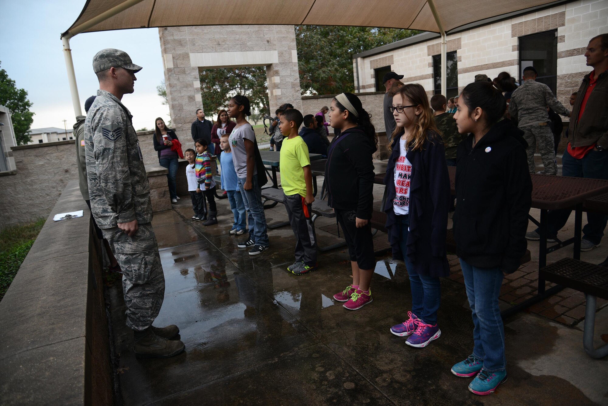Laughlin members display the position of attention to military and local children on Laughlin Air Force Base, Texas, Nov. 7, 2015. During Operation XL, the children learned how to stand at the positions of attention and parade rest along with formation techniques. (U.S. Air Force photo by Airman 1st Class Ariel D. Partlow)