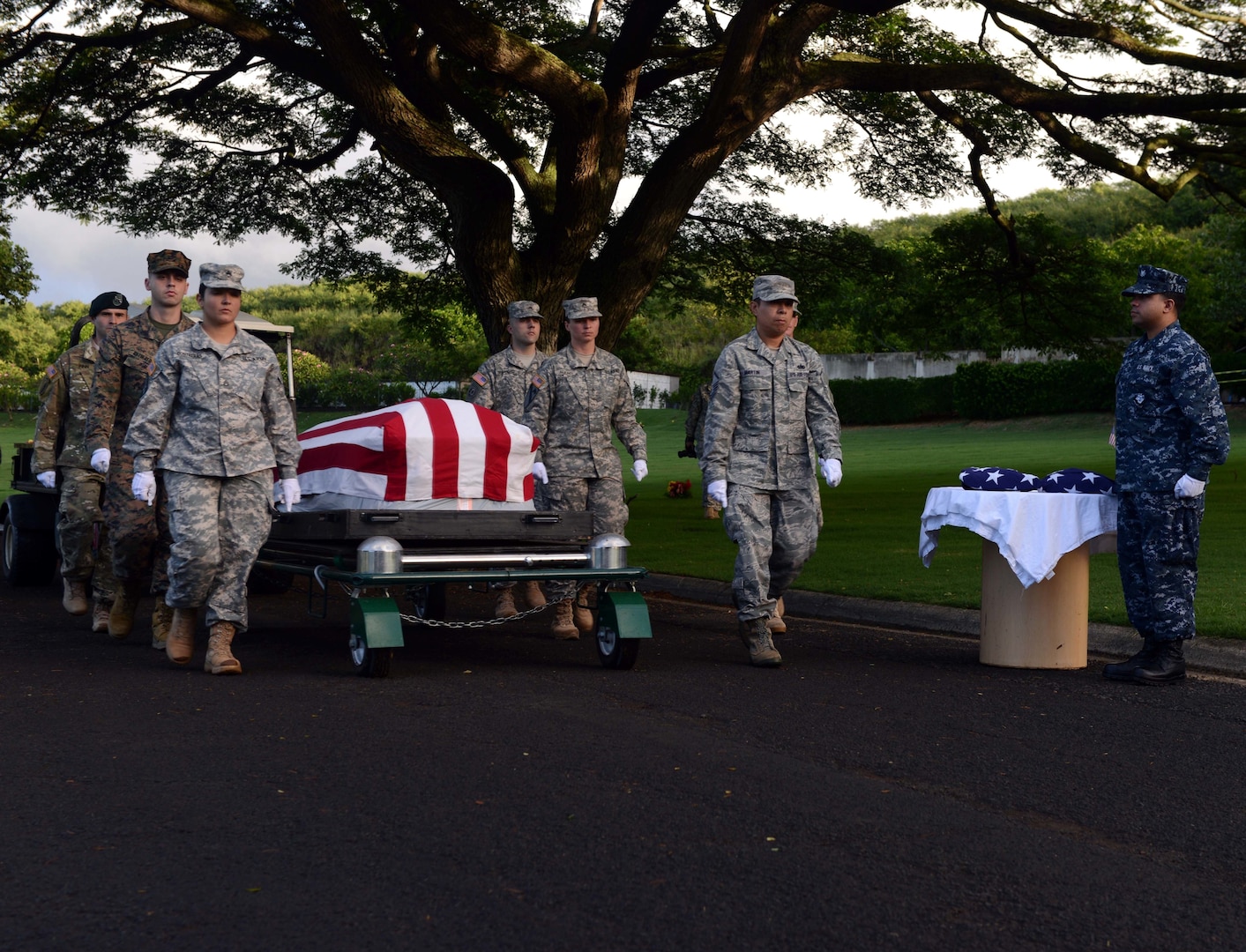 Members of the Defense POW/MIA Accounting Agency (DPAA) march alongside a disinterred casket holding the remains of unknown USS Oklahoma service members during a disinterment ceremony at the National Memorial Cemetery of the Pacific in Honolulu, Nov. 5, 2015. Today’s ceremony was the final disinterment for the USS Oklahoma. The DPAA mission is to provide the fullest possible accounting for our missing personnel to their families and the nation. (U.S. Air Force photo by Staff Sgt. La'Shanette Garrett/Released)