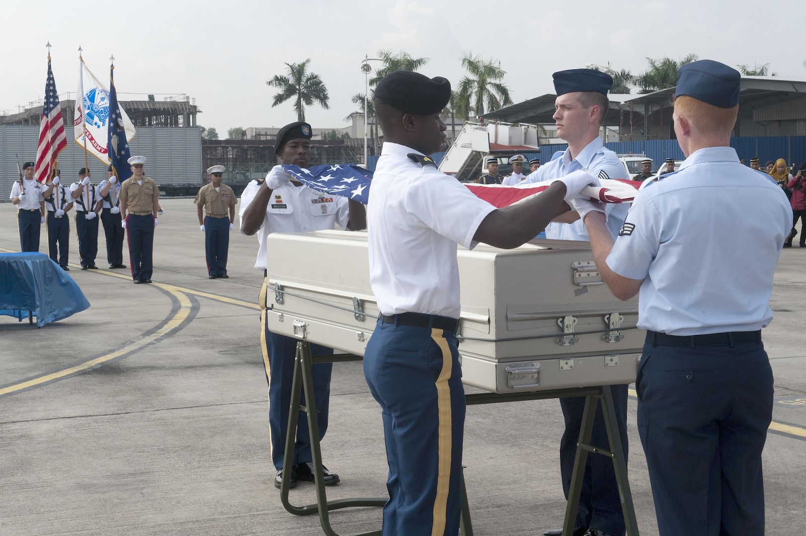 A joint service team prepares to drape an American flag over a casket during a repatriation ceremony at Subang Air Base, Malaysia, Nov. 5, 2015. The 15-member team comprised of members of the Defense POW/MIA Accounting Agency as well service members from U.S. Army Pacific and Pacific Air Force Command, was sent from Hawaii to honor the remains of a fallen service member who paid the ultimate sacrifice when his plane went down over Malaysia in 1945. The ceremony signifies the transfer of the remains from Malaysia back to the U.S. where the service member can be ultimately identified and returned home. The ceremony marks the first of its kind between the two countries. The mission of the Defense POW/MIA Accounting Agency is to provide the fullest possible accounting for our missing personnel to their families and the nation. (U.S. Air Force photo by Staff Sgt. Brian J. Valencia)