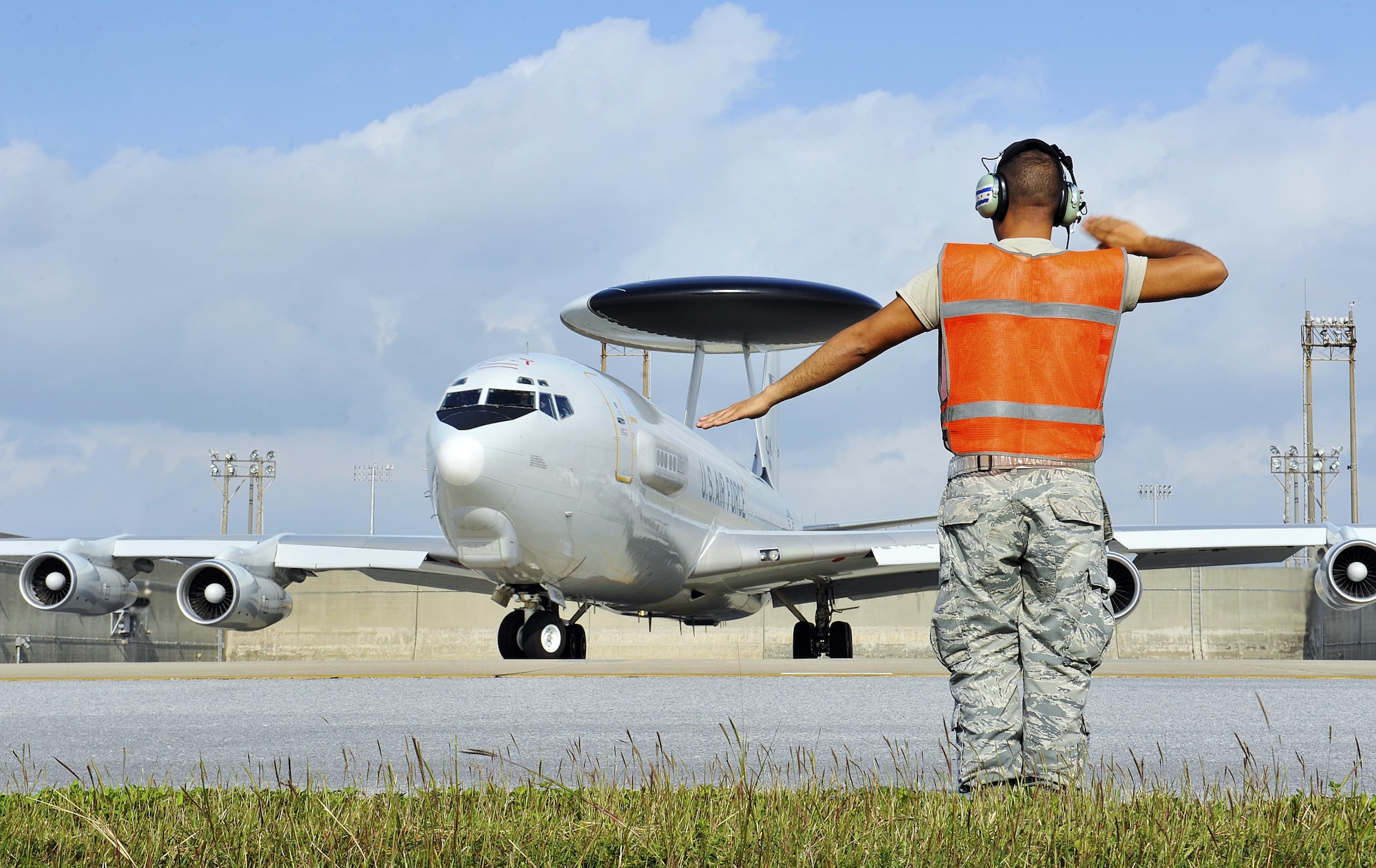 U.S. Air Force Staff Sgt. Ricardo Huerta, 961st Aircraft Maintenance Squadron dedicated crew chief, marshals an E-3 Sentry airborne warning and control system, Nov. 10, 2015, at Kadena Air Base, Japan. The AWACS aircraft provides all-weather surveillance, command, control and communications needed by commanders of U.S., NATO and other allied air defense forces. (U.S. Air Force photo by Naoto Anazawa/Released)