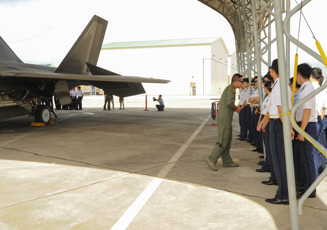 U.S. Air Force Capt. Jared Fujii, Hawaiian Raptors pilot, listens to a question from a Republic of Korea Air Force Academy cadet about U.S. Air Force F-22 Raptors, Nov. 10, 2015, Joint Base Pearl Harbor-Hickam, Hawaii. The cadet's visit was part of an effort to build a foundation of partnership and interoperability between Headquarters Pacific Air Forces and future ROKAF leaders. (U.S. Air Force photo by Tech. Sgt. Amanda Dick/Released)