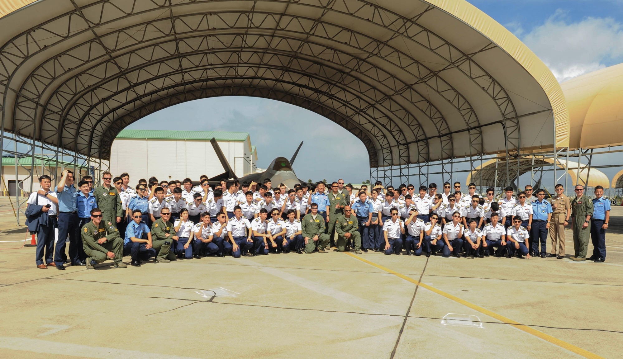 Republic of Korea Air Force Academy cadets take a photo with Hawaiian Raptors pilots after learning about capabilities of the U.S. Air Force F-22 Raptor, Nov. 10, 2015, Joint Base Pearl Harbor-Hickam, Hawaii. The cadet's visit was part of an effort to build a foundation of partnership and interoperability between Headquarters Pacific Air Forces and future ROKAF leaders. (U.S. Air Force photo by Tech. Sgt. Amanda Dick/Released)