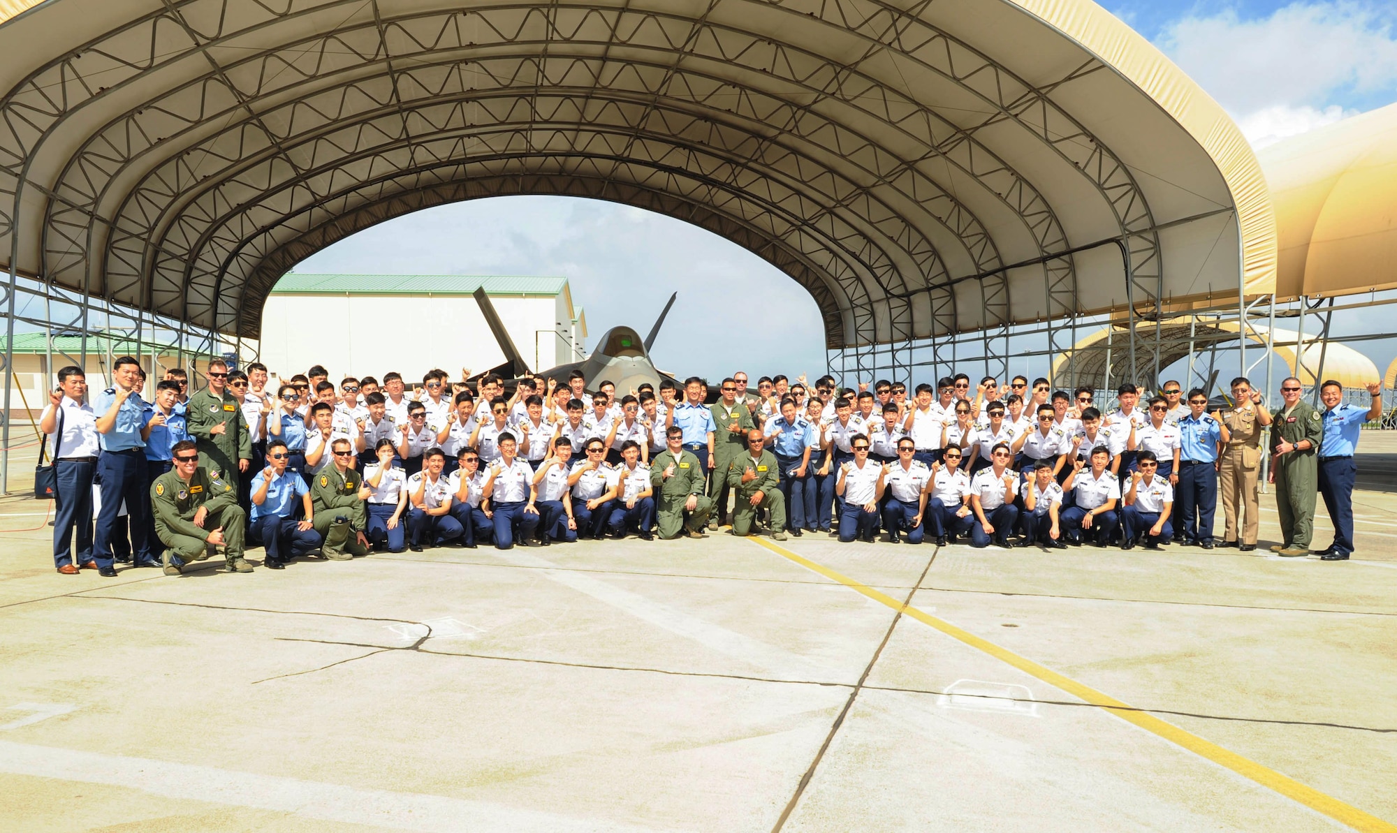 Republic of Korea Air Force Academy cadets take a photo with Hawaiian Raptors pilots after learning about capabilities of the U.S. Air Force F-22 Raptor, Nov. 10, 2015, Joint Base Pearl Harbor-Hickam, Hawaii. The cadet's visit was part of an effort to build a foundation of partnership and interoperability between Headquarters Pacific Air Forces and future ROKAF leaders. (U.S. Air Force photo by Tech. Sgt. Amanda Dick/Released)
