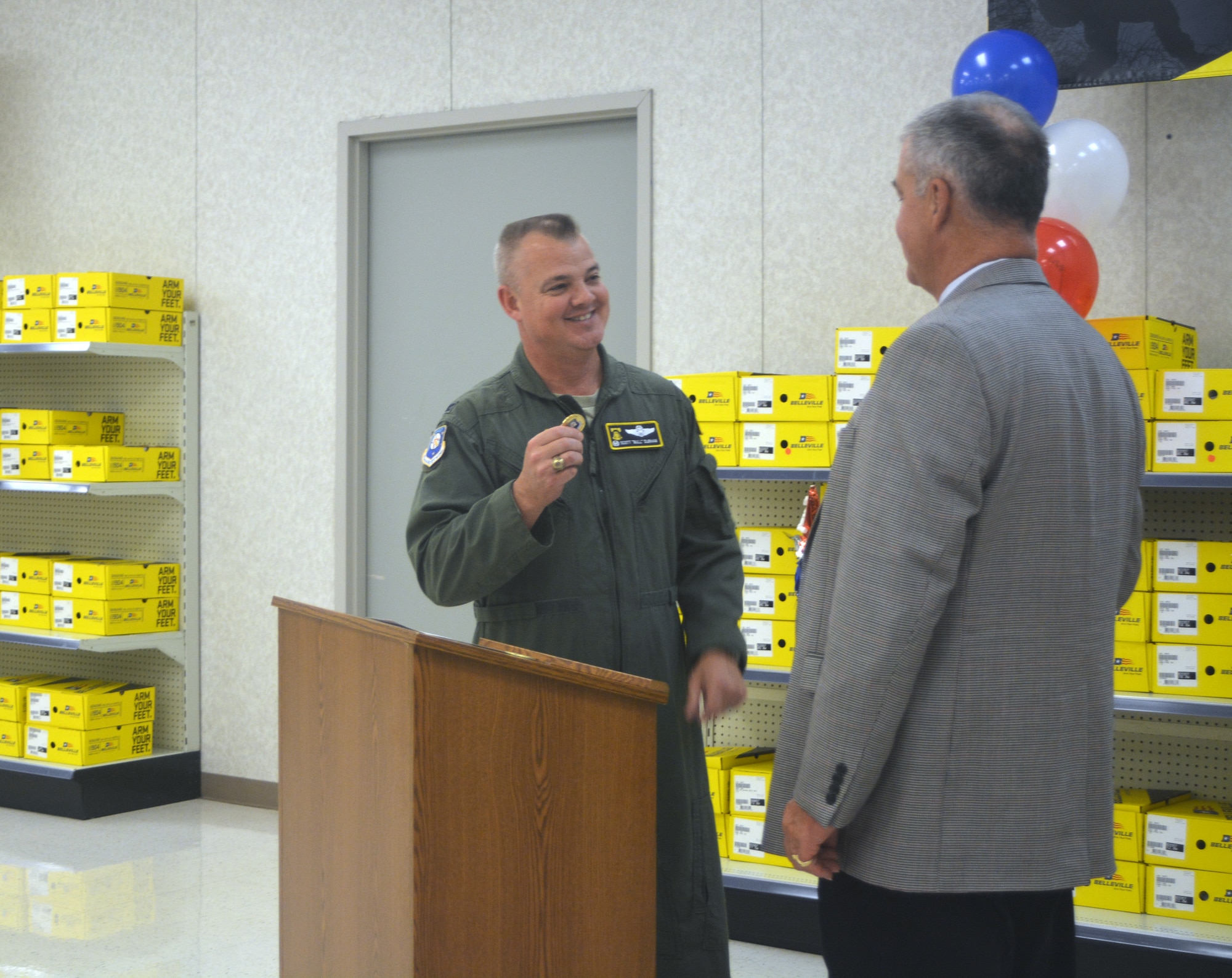 Col. Scott Durham, 512th Airlift Wing commander, presents a wing coin to Frederick Puente, the president of Blind Industries and Services of Maryland, during a ceremony Nov. 3, 2015, on Dover Air Force Base, Del. The celebration honored the 20th anniversary of the base’s Ability One Base Supply Center. (U.S. Air Force photo/Master Sgt. Veronica Aceveda)
