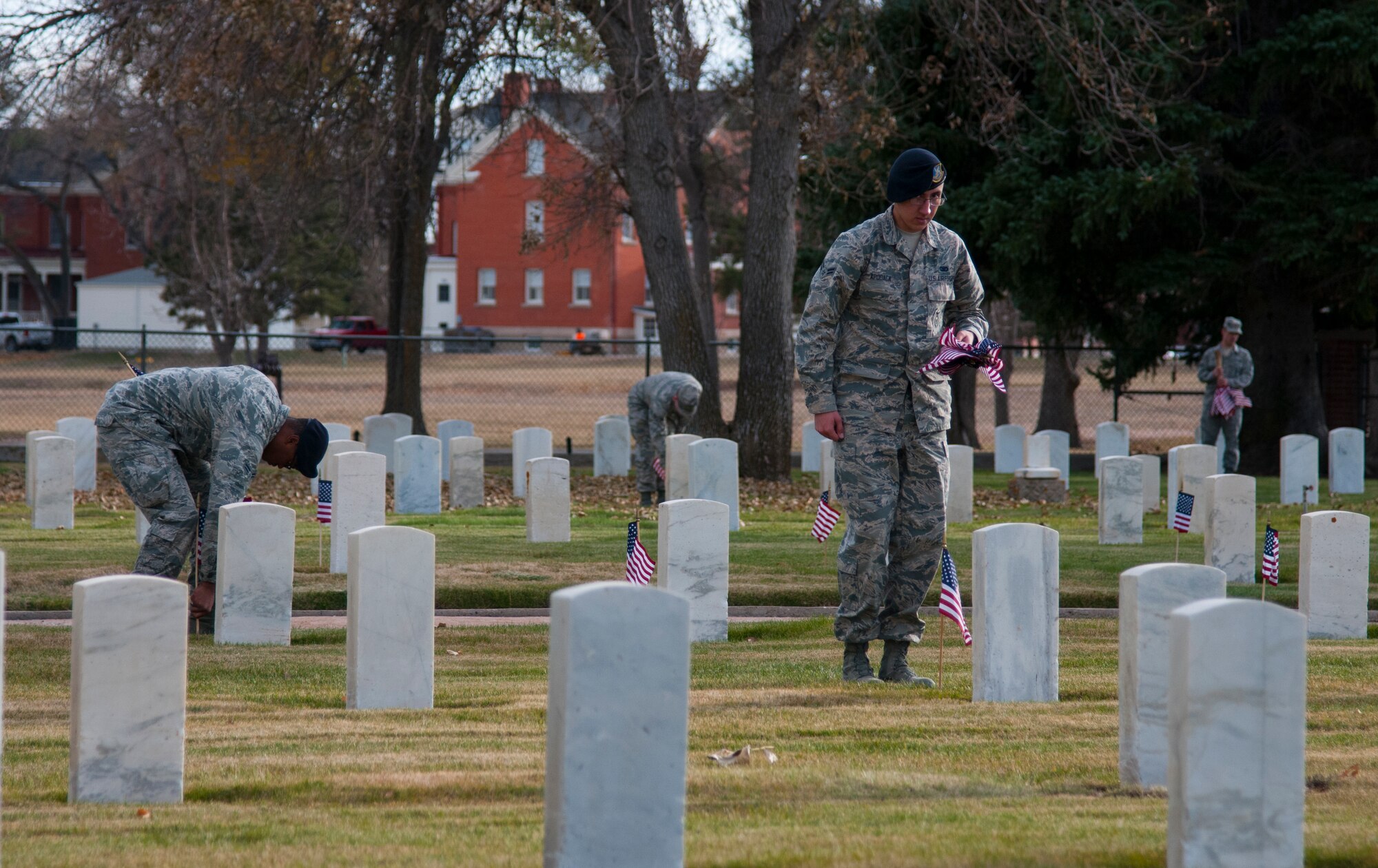 Ninetieth Missile Wing ceremonial guardsmen place flags at the graves of veterans interred at the F.E. Warren Air Force Base, Wyo., cemetery Nov. 9, 2015, in observance of Veterans Day. Twice each year, for Veterans Day and Memorial Day, Airmen from the wing place flags for the veterans buried there and render a salute in honor of their service. (U.S. Air Force photo by Senior Airman Jason Wiese)