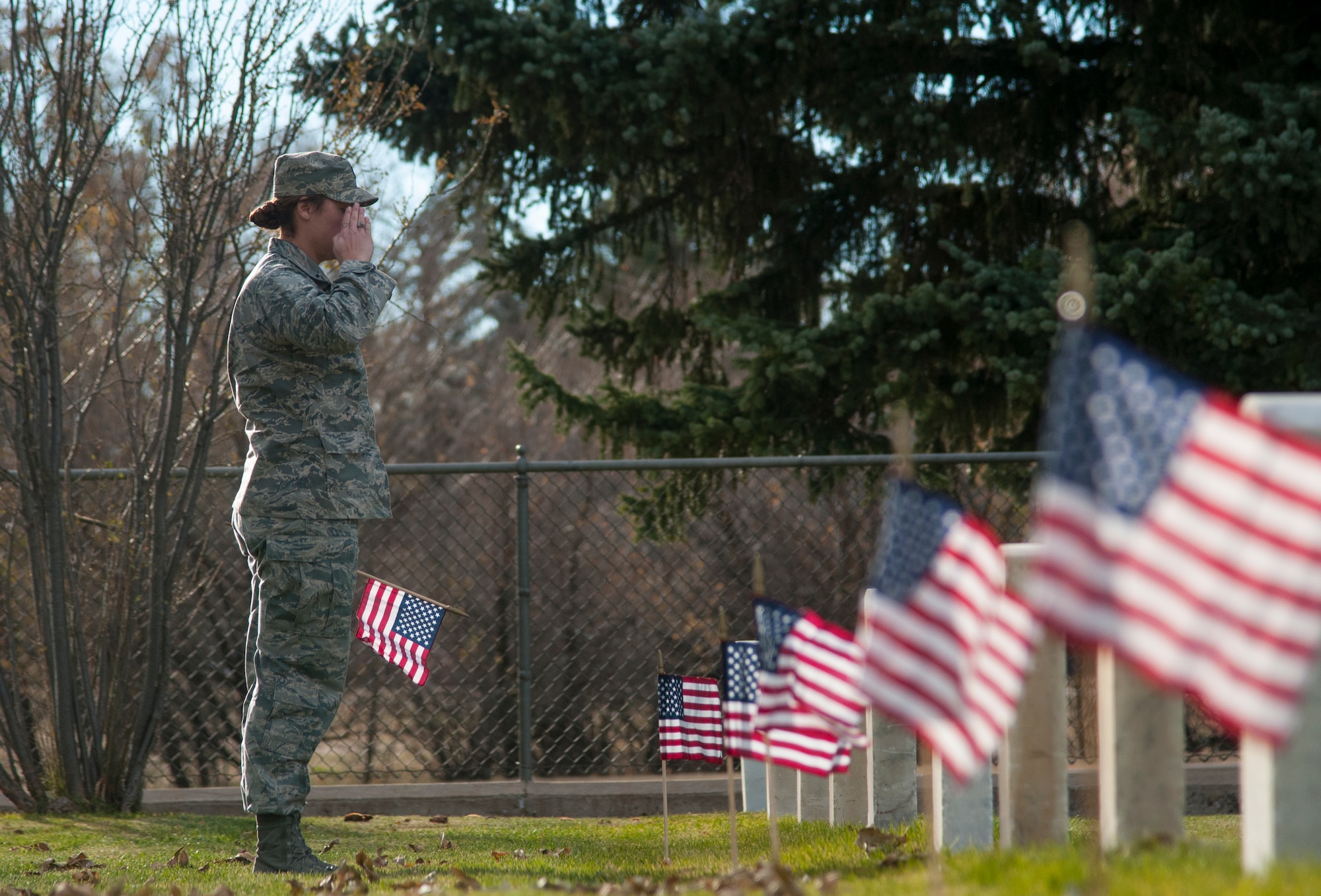 First Lt. Katie Moorkamp, 90th Force Support Squadron Sustainment Services Flight commander, salutes the grave of a veteran interred in the F.E. Warren Air Force Base, Wyo., Nov. 9, 2015. Moorkamp and other 90th Missile Wing Airmen paid respect to each of the veterans buried in the cemetery as an early Veterans Day observance. (U.S. Air Force photo by Senior Airman Jason Wiese)