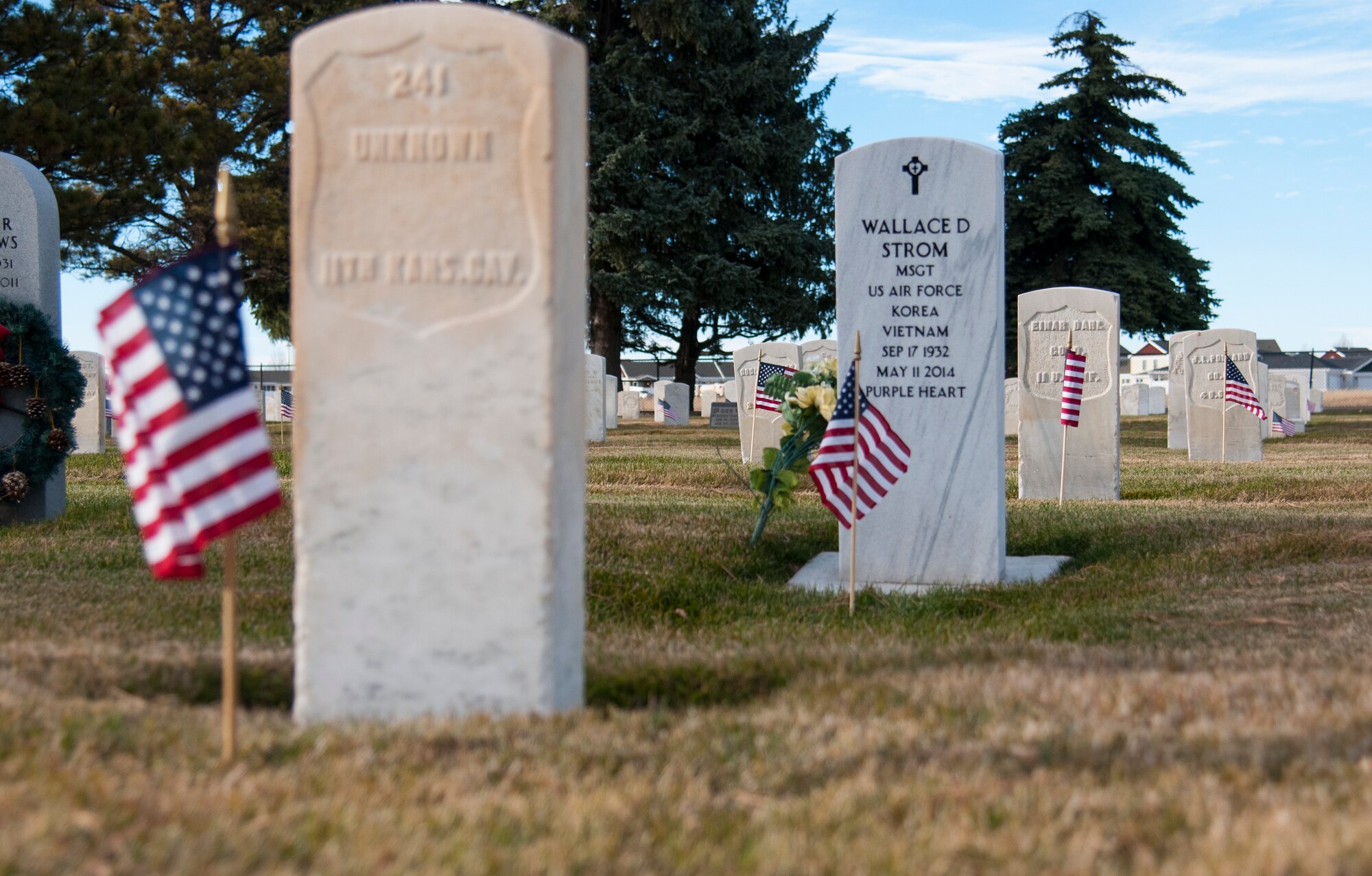 American flags wave in front of the headstones of veterans' graves in the F.E. Warren Air Force Base, Wyo., Nov. 9, 2015. The flags were placed by 90th Missile Wing ceremonial guardsmen and Airmen from the 90th Force Support Squadron in honor of Veterans Day. (U.S. Air Force photo by Senior Airman Jason Wiese)