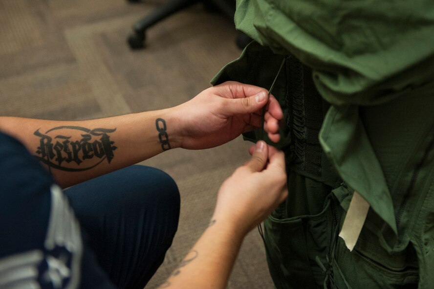 Staff Sgt. Jose Ibarra, U.S. Air Force Thunderbirds aircrew flight equipment technician, laces up Caitlyn Chastain’s G-suit, Nov. 6, 2015, at Moody Air Force Base, Ga. Chastain, a local news reporter, was also fitted for a helmet and issued boots for a flight she was taking with the Thunderbirds. (U.S. Air Force Airman 1st Class Kathleen D. Bryant/Released)
