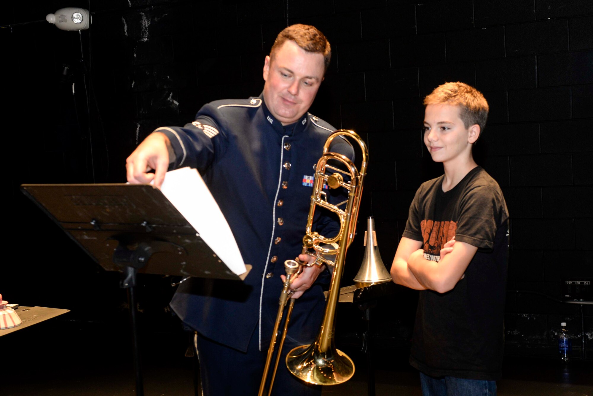 Staff Sgt. Brad Femiak, U.S. Air Force Heritage of America Band audio engineer, shows a member of the audience sheet music after their performance at the Paramount Theater, Nov. 5, 2015, in Goldsboro, North Carolina. The ensemble performs a diverse repertoire featuring orchestral transcriptions, patriotic favorites, jazz standards, new compositions and distinctive arrangements. (U.S. Air Force photo/Airman 1st Class Ashley Williamson)