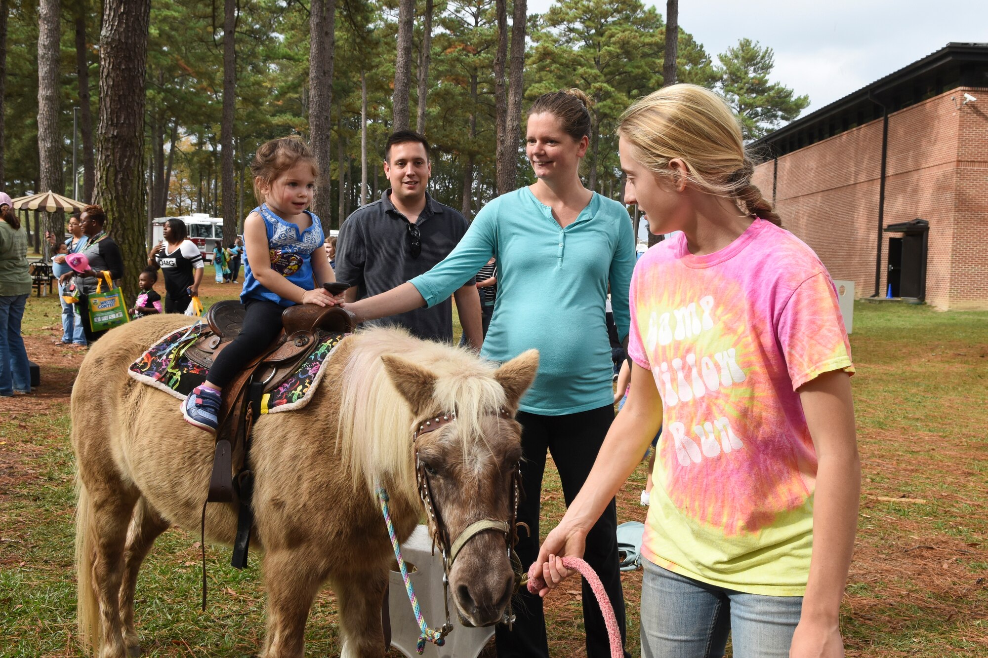 A young member of Team Seymour receives a pony ride during the Military Family Appreciation Month celebration, Nov. 7, 2015, at Seymour Johnson Air Force Base, North Carolina. The event featured activities at the youth center for the families of Airmen assigned to the installation. Stepping Stone Stables from Pikeville, North Carolina, provided horses and handlers for the event. (U.S. Air Force photo/Senior Airman Aaron J. Jenne)