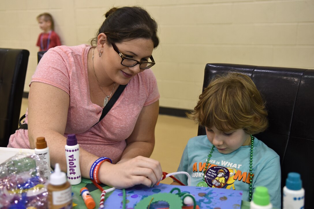 Onnolea Zapata (left), wife of Senior Airman Roberto Zapata, 4th Aircraft Maintenance Squadron crew chief, and her child make a holiday ornament during the Military Family Appreciation Month celebration, Nov. 7, 2015, at Seymour Johnson Air Force Base, North Carolina.  Team Seymour families were invited to the event to honor their sacrifices and commitment to the military lifestyle. Members of the USO, Airman and Family Readiness Center and other on-base volunteers manned activity stations. (U.S. Air Force photo/Senior Airman Aaron J. Jenne)