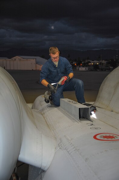 U.S. Air Force Airman 1st Class Bryan Betz, 355th Aircraft Maintenance Squadron assistant dedicated crew chief, works on top of an A-10C Thunderbolt II at Davis-Monthan Air Force Base, Ariz., Nov. 4, 2015. Crew chiefs cover intakes to prevent foreign objects like rocks, screws, weeds and animals from getting inside the jet. (U.S. Air Force photo by Airman 1st Class Ashley N. Steffen/Released)