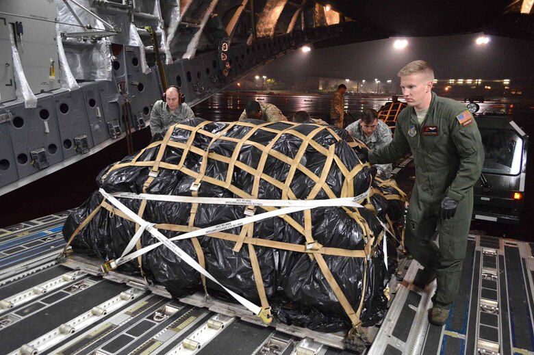 U.S. Air Force Staff Sgt. Kevin Spears, a C-17 Globemaster III aircraft loadmaster assigned to the 517th Airlift Squadron, Joint Base Elmendorf-Richardson, Alaska, guides the loading of U.S. Army T-11 parachutes onto the aircraft during exercise Ultimate Reach Nov.3, on Green Ramp, Pope Army Airfield, North Carolina. Eighteenth Air Force units, partnered with the Army's 82nd Airborne Division, are participating in Exercise Ultimate Reach Nov. 2-8. Ultimate Reach is an annual U.S. Transportation Command-sponsored live-fly exercise designed to exercise the ability of 18th Air Force (Air Forces Transportation) to plan and conduct strategic airdrop missions. This iteration of Ultimate Reach partners with NATO Exercise Trident Juncture, currently being held in locations across Europe. C-17 crews from Joint Base Charleston, S.C.; Joint Base Lewis-McChord, Washington; and Joint Base Elmendorf-Richardson, Alaska, will fly more than 500 Paratroopers of the 82nd Airborne Division's 2nd Brigade Combat Team across the Atlantic to conduct a joint forcible entry exercise over Zaragoza Spain. KC-10 aerial refueler crews from Joint Base McGuire-Dix-Lakehurst, New Jersey, and Travis Air Force Base, California, will provide refueling support during the mission. The exercise serves to enhance 18th Air Force's interoperability and teamwork with NATO allies and sister services. More than 5,000 U.S. service members are participating in Trident Juncture. Elements of the exercise are being conducted in Spain, Portugal, Italy, Belgium, Canada, Germany, the Netherlands, Norway and at sea. Trident Juncture is the largest NATO exercise conducted in the last 20 years and serves as an annual NATO Response Force certification exercise for 2016. Trident Juncture formally ends Nov. 6. (U.S. Air Force photo/Marvin Krause)