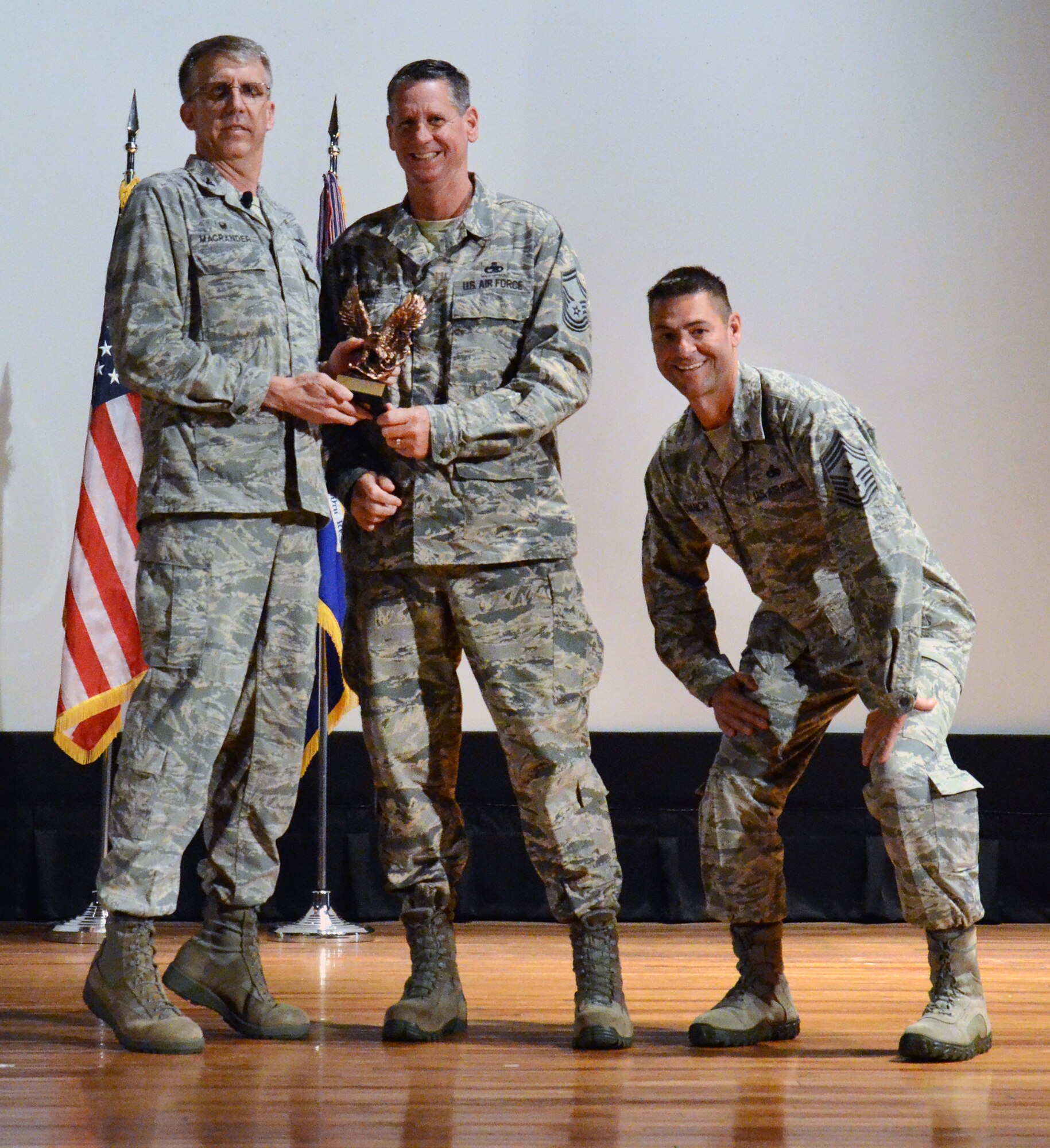 920th Rescue Wing Commander Col. Jeffrey Macrander (left) and wing Command Chief, Chief Master Sgt. Timothy Bianchi (right) bring a little levity to the stage for quarterly-award winner Senior Master Sgt. Dennis Grant during a commander’s call held at the base theater here Nov. 8. Sergeant Grant, from the wing’s maintenance squadron, was named outstanding senior NCO for the second quarter of 2015. (U.S. Air Force photo/Master Sgt. Paul Flipse) 