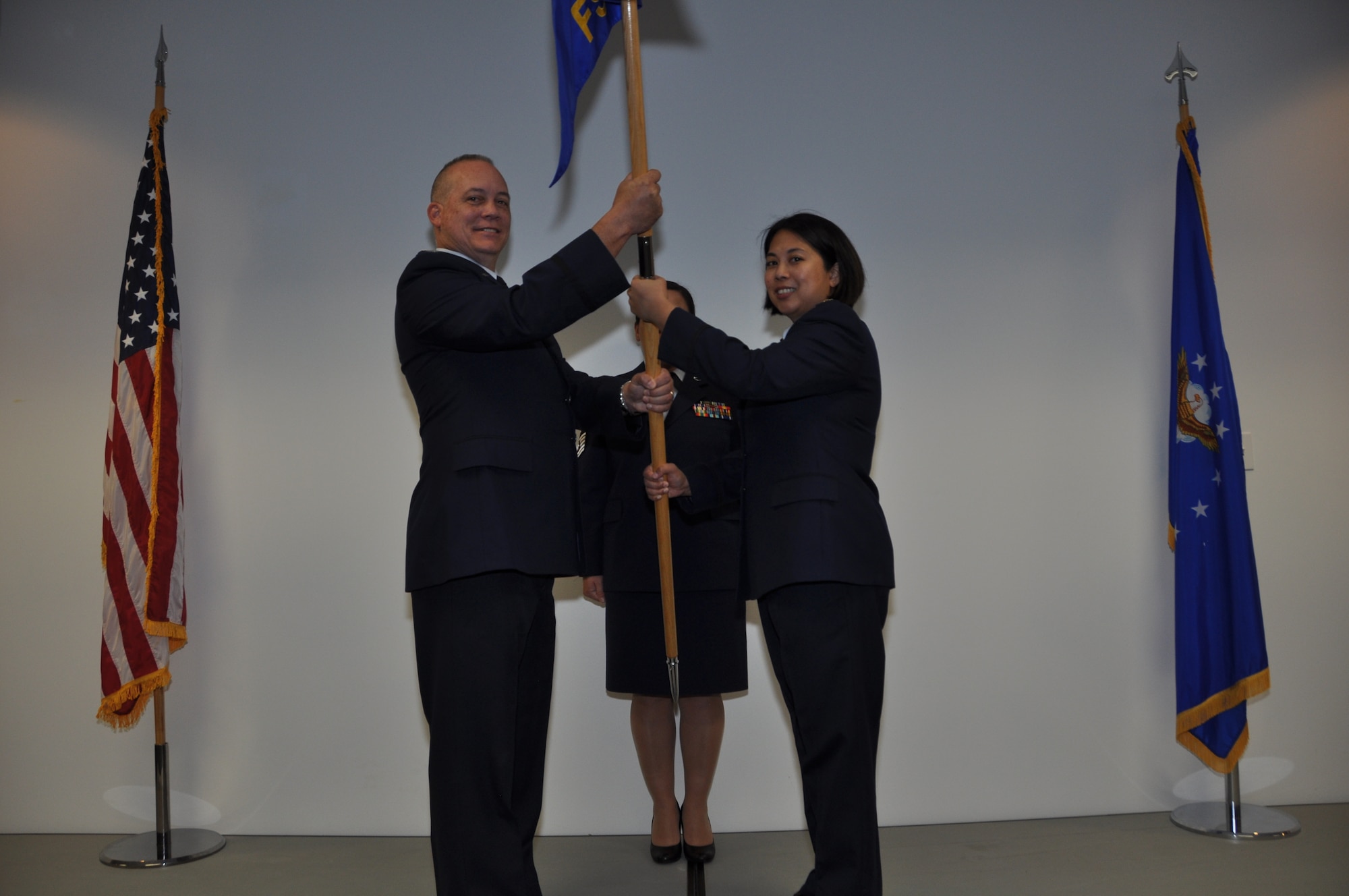 NAVAL AIR STATION FORT WORTH JOINT RESERVE BASE, Texas - Maj. Myla Abejuela (right) receives guidon from Col. Jeffrey Barnett, 301st Mission Support Group commander, as she assumes command of the 301st Force Support Squadron here Nov 7, 2015, while Master Sgt. Tina Bennett, 301 FSS first sergeant, stands at attention.  Prior to assuming command, Abejuela served as the wing executive officer at the 920th Wing, Nellis Air Force Base, Nev. (U.S. Air Force photo/Senior Airman Jeromie Cano)