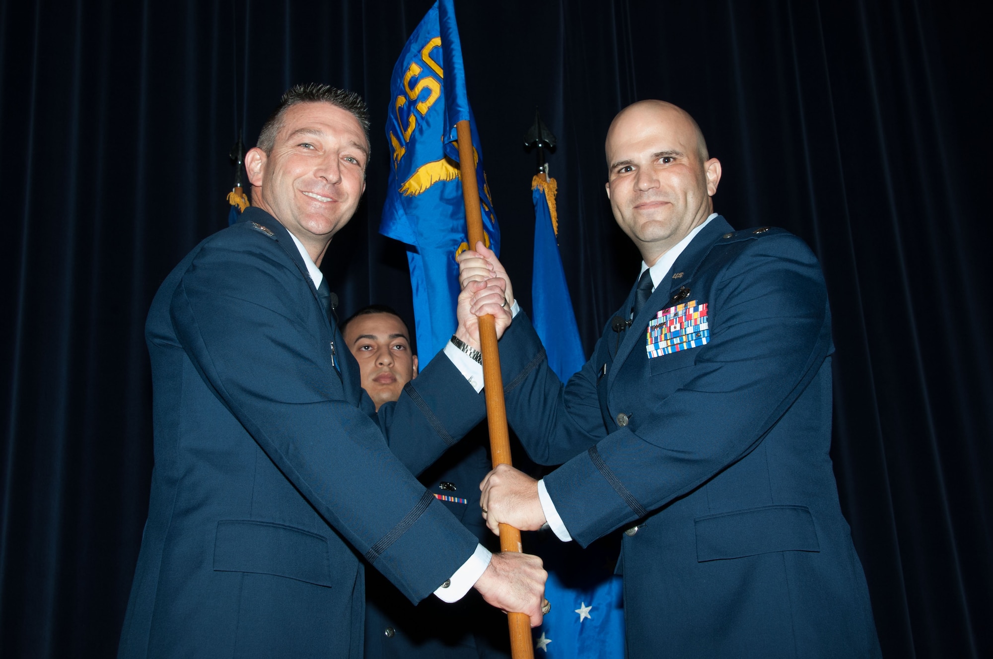 Col. Brian Hastings, Air Command and Staff College commandant hands over command of the 38th Student Squadron to Lt. Col. Richard Major during the ACSC 38th STUS Activation and Assumption of Command ceremony November 2, 2015, at Maxwell Air Force Base, Alabama. The 38th STUS was re-activated for a fourth time in 43 years to better support over 500 ACSC students. (U.S. Air Force photo by Bud Hancock)
