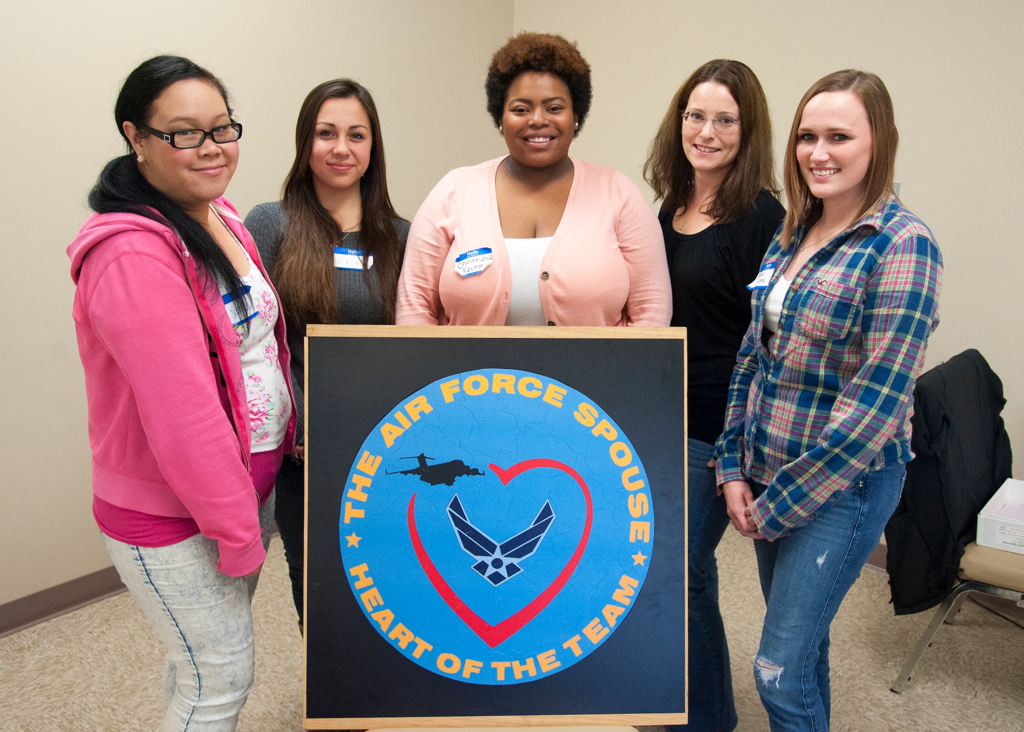 Team Dover spouses and mentors pose with a puzzle they  completed  during Dover's Heart Link, Nov. 5, 2015, at Dover Air Force Base, Del. The class included briefings on military pay and benefits, housing options and gave the group a chance to make friends and team-build through sponsored activities. (U.S. Air Force photo/Staff Sgt. Jared Duhon) 