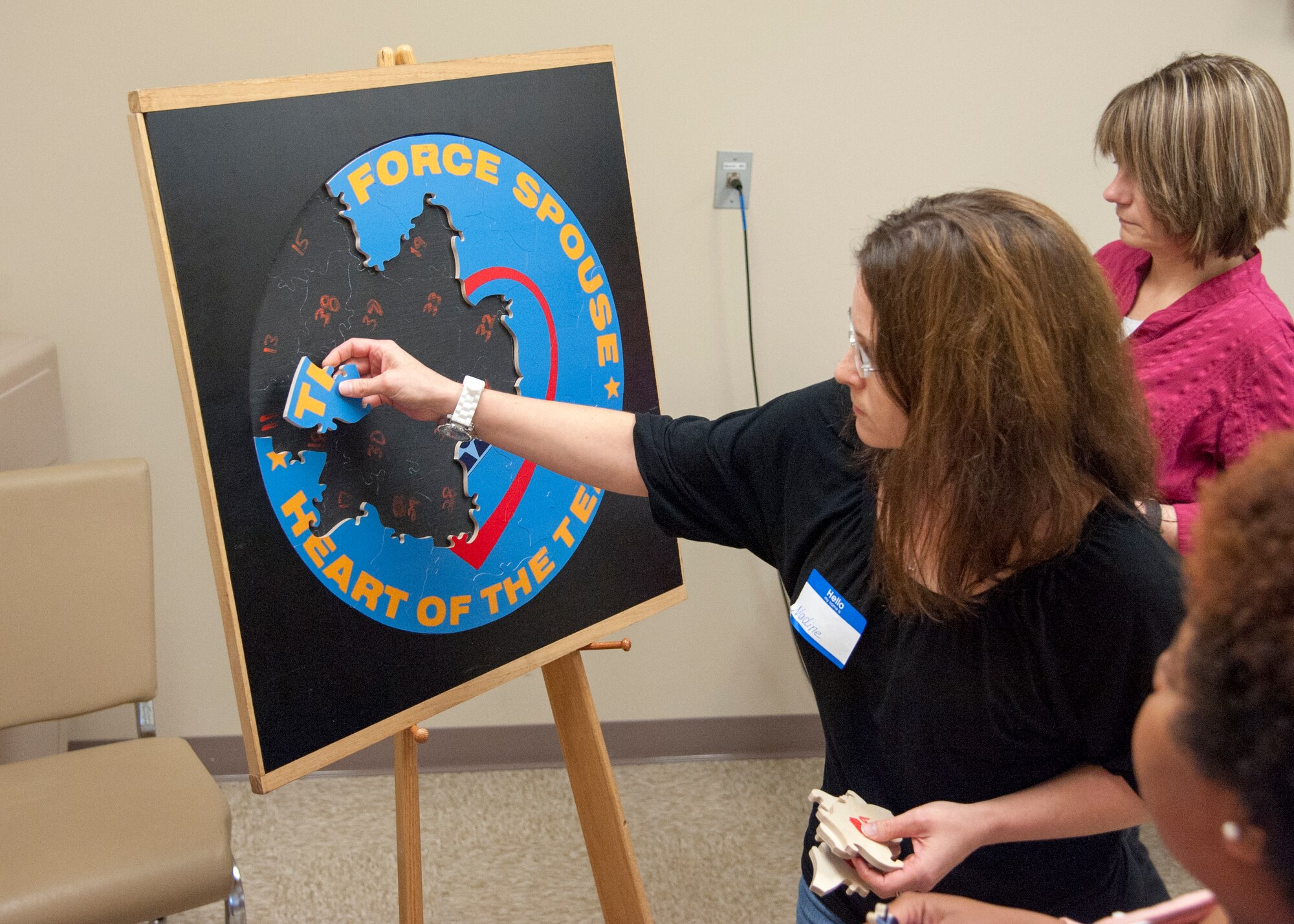 Nadine Peifer, wife of Tech Sgt. Daniel Peifer, 436th Civil Engineer Squadron, helps piece together a Heart Link seal puzzle during the Heart Link Spouse Orientation Program Nov. 5, 2015, at Dover Air Force Base, Del. The class included briefings on military pay and benefits, housing options and gave the group a chance to make friends. (U.S. Air Force photo/Staff Sgt. Jared Duhon)