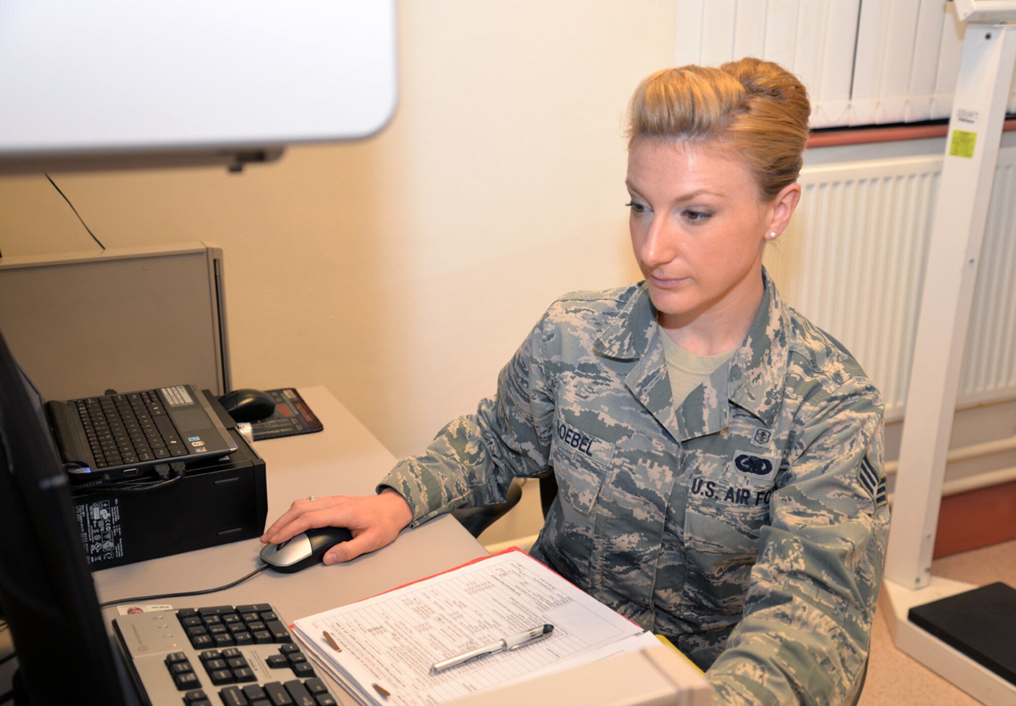 U.S. Air Force Senior Airman Elizabeth Goebel, 48th Aerospace Medicine Squadron Flight Medicine Clinic flight and operational medical technician, checks a patient’s medical records after a preventative health assessment Oct. 21, 2015, at the 48th Aerospace Medicine Squadron Flight Medicine Clinic on RAF Mildenhall, England. Although assigned to RAF Lakenheath, medical technicians work rotations at the nearby base for Team Mildenhall customers. They take care of U.S. Air Force members on flying status, and their dependents (age 12 and above). The clinic also provides medical services to U.S. Air Force firefighters. (U.S. Air Force photo by Karen Abeyasekere/Released)