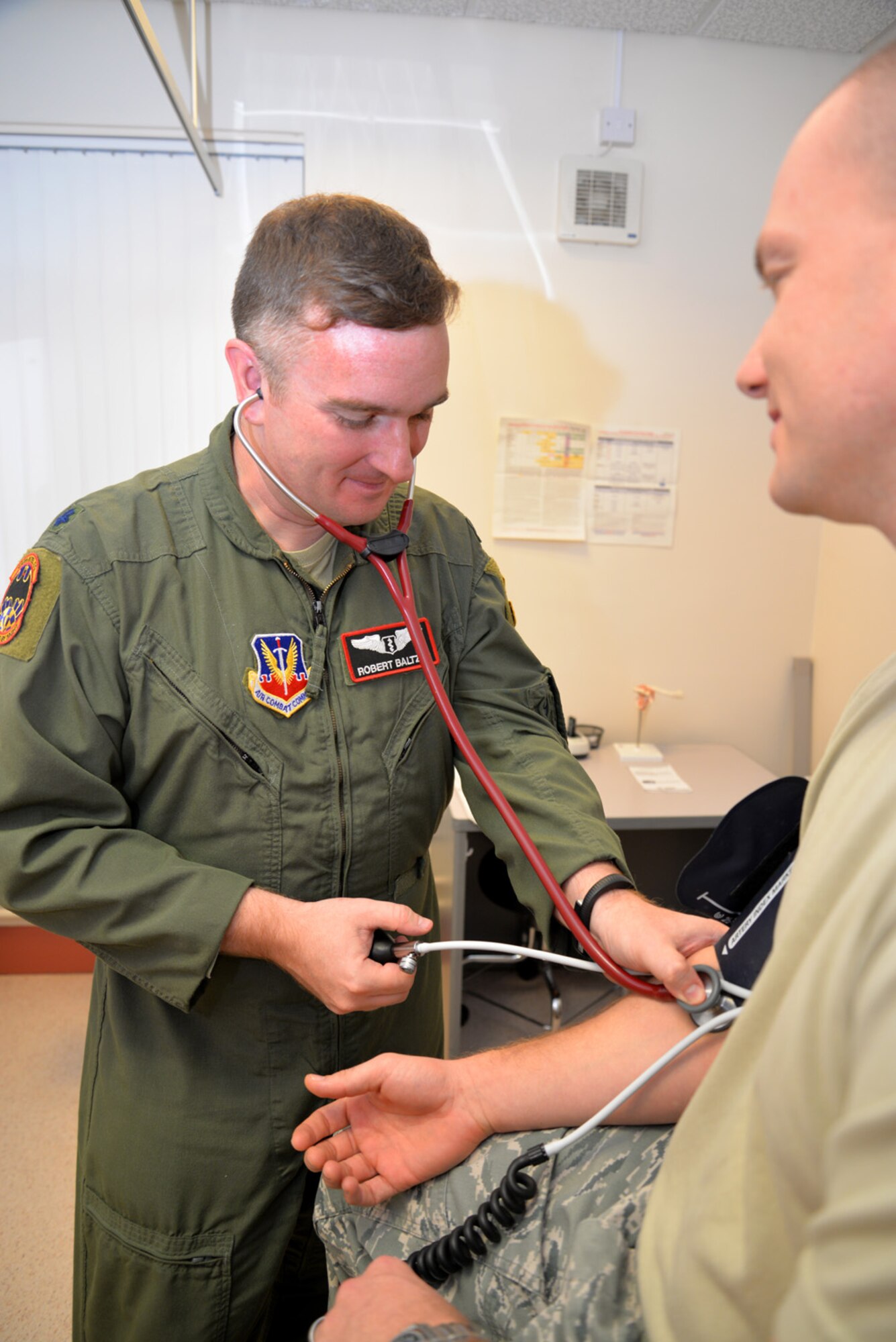 U.S. Air Force Lt. Col. Robert Baltzer, left, 488th Intelligence Squadron medical element flight surgeon, performs a blood pressure check on a U.S. Air Force Airman Oct. 21, 2015, at the 48th Aerospace Medicine Squadron Flight Medicine Clinic on RAF Mildenhall, England. Located on RAF Mildenhall, the medical technicians are assigned to RAF Lakenheath, but perform rotations at the nearby base. The flight surgeons are the squadron medical element attached to flying squadrons, and work in conjunction with independent duty medical technicians, providing medical support to aircrew. (U.S. Air Force photo by Karen Abeyasekere/Released)