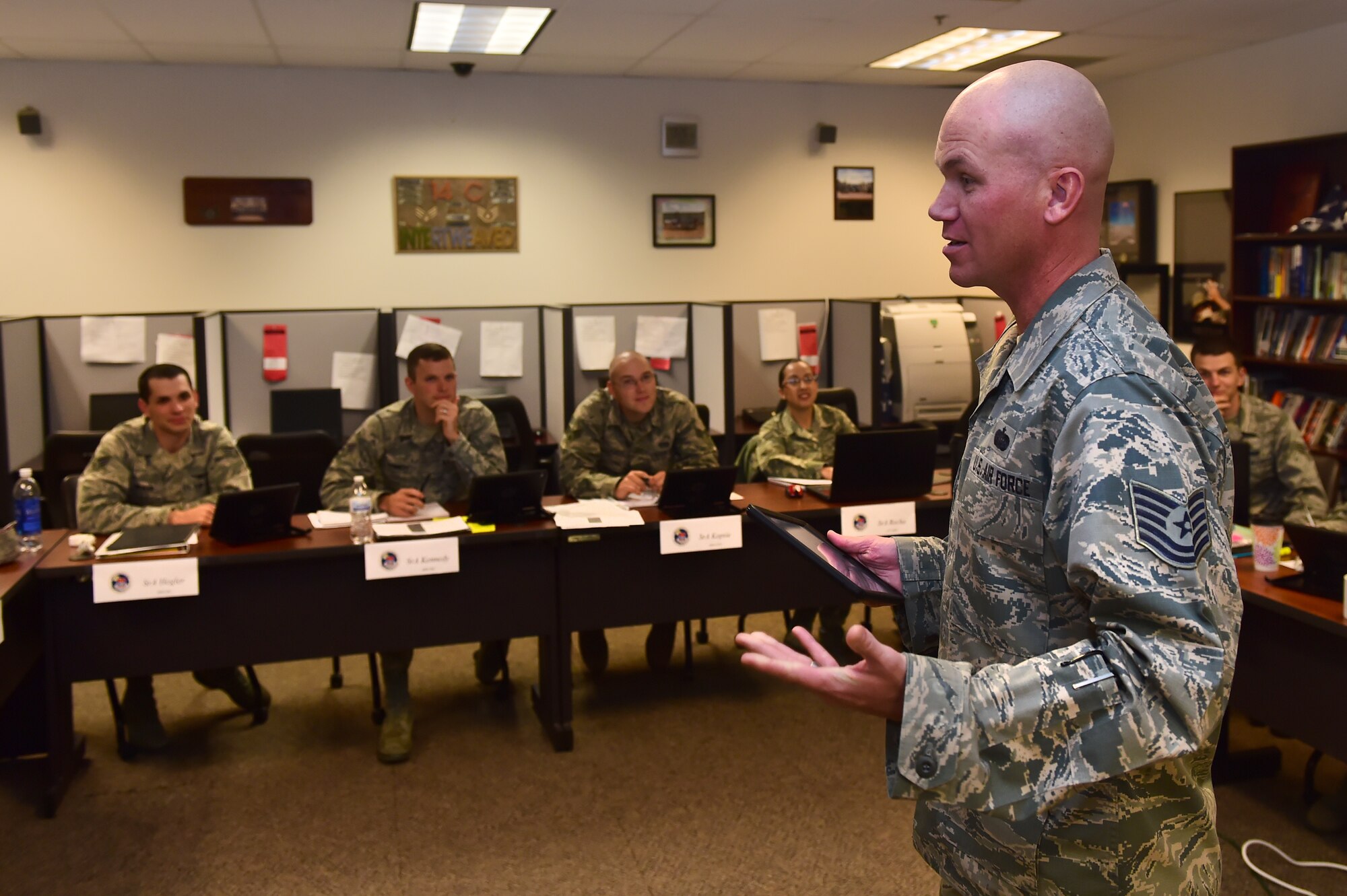 Tech. Sgt. James Jackson, 460th Space Wing Airman Leadership School instructor, uses an iPad to teach an ALS class Nov. 9, 2015, on Buckley Air Force Base, Colo. ALS instructors and students utilizes the capabilities of iPads in order to improve teaching techniques and reduce resource costs. (U.S. Air Force photo by Airman 1st Class Luke W. Nowakowski/Released)