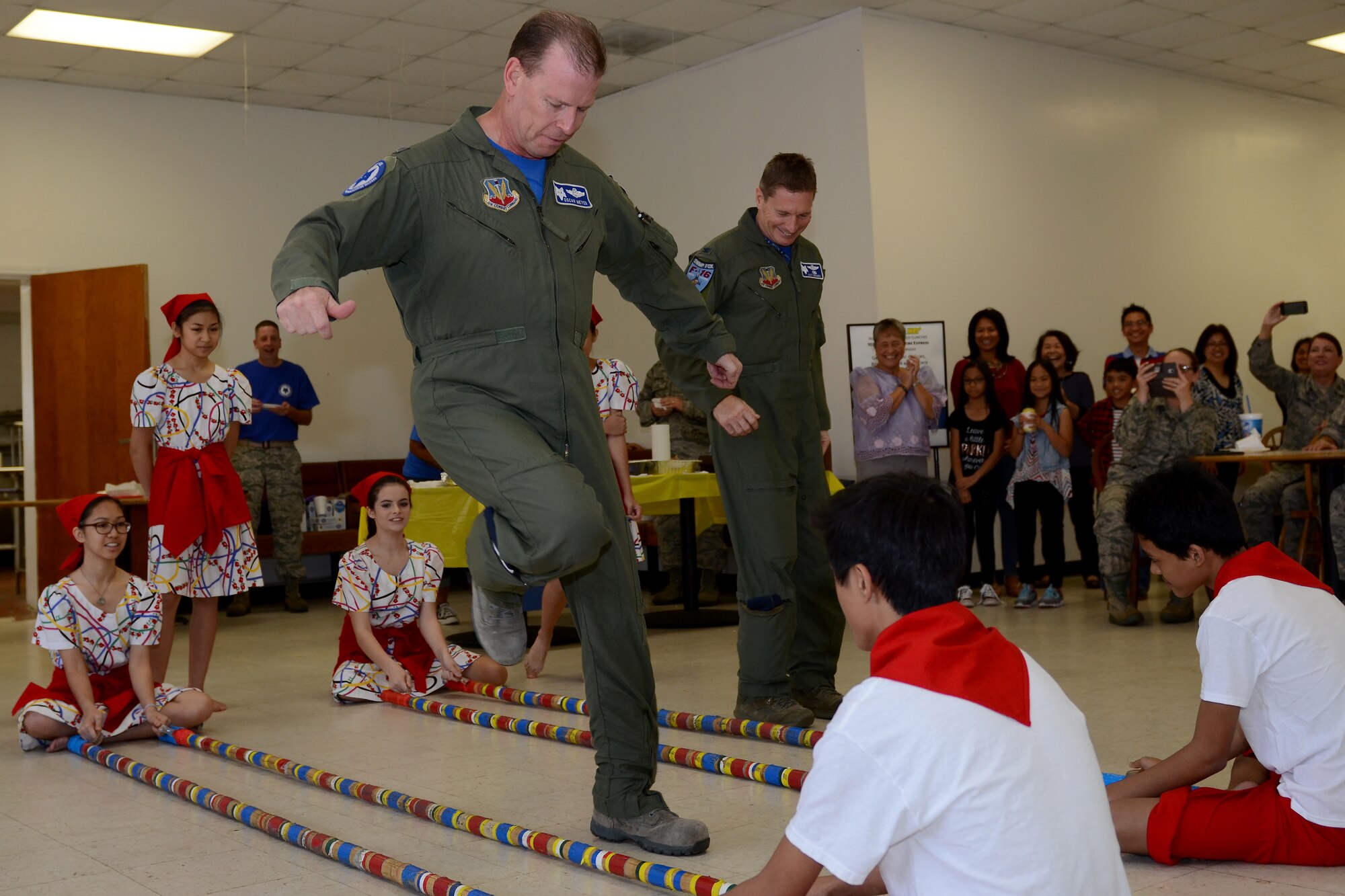 U.S. Air Force Col. David Meyer (foreground), 169th Fighter Wing commander and Col. Scott Bridgers, the 169th Maintenance Group commander, learn the Tinikling Dance, a Filipino-originated dance the teen and youth dance troop from the Filipino-American Association of Greater Columbia performed at McEntire Joint National Guard Base, S.C., Nov. 7, 2015, during the annual Diversity Day event in the base canteen. Diversity Day combines the Department of Defense's monthly diversity programs into a one day event for guardsmen to learn about other cultures and to celebrate diversity. (U.S. Air National Guard photo by Airman 1st Class Ashleigh Pavelek/RELEASED)