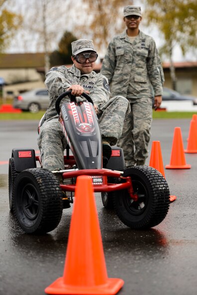 U.S. Air Force Tech. Sgt. Michael Cato, a 52nd FW traffic manager, drives a go-kart while wearing drunk goggles on the Saber driving course during operation winterize, Nov. 6, 2015, at Spangdahlem Air Base, Germany. A competition was held among the participants to see who could get through the course with the least amount of traffic cone hits. (U.S. Air Force photo by Staff Sgt. Christopher Ruano/Released)