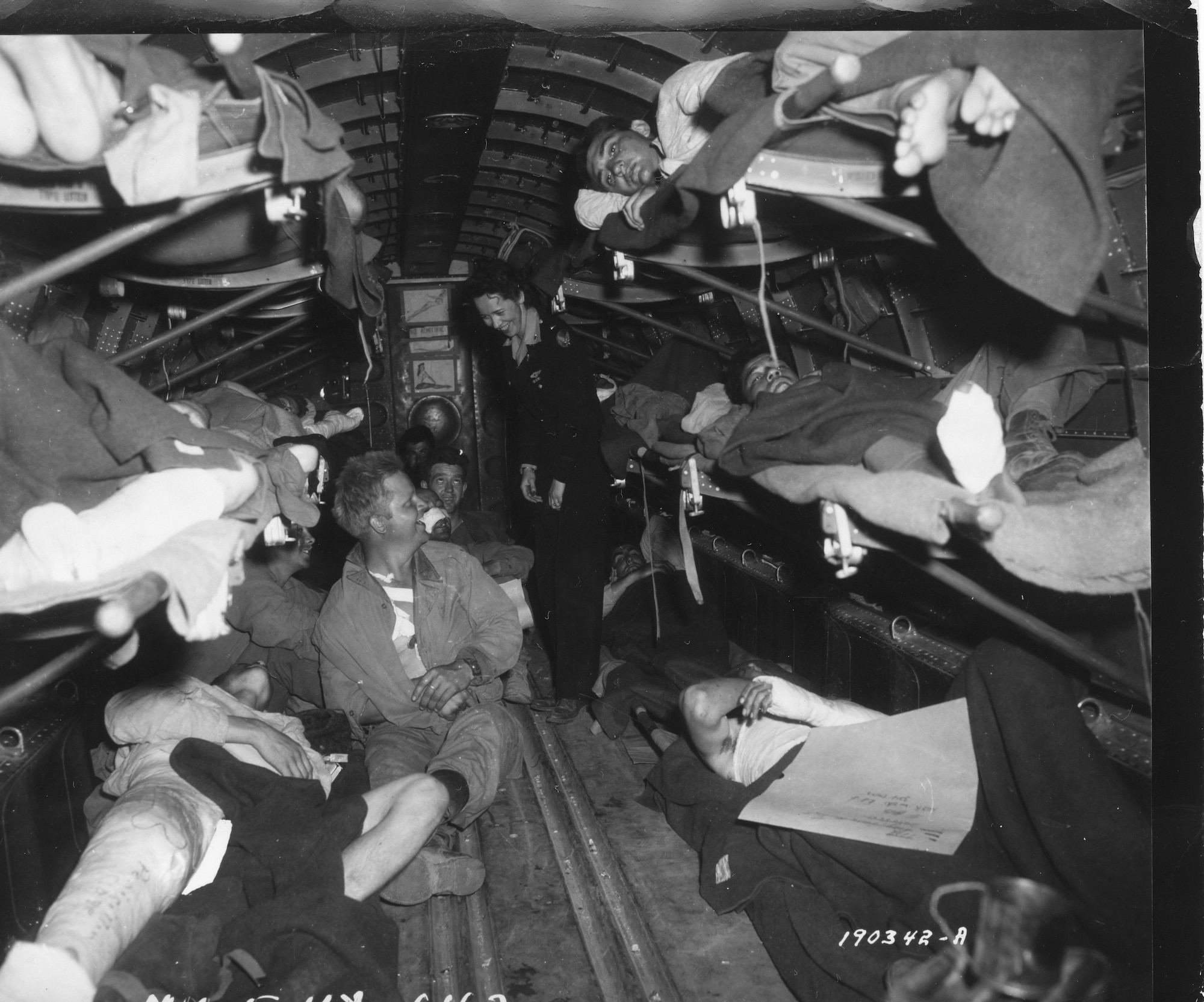 A flight nurse cares for wounded soldiers onboard a C-47 Skytrain transport plane. (Photo Credit: AFMS Historian’s Office)
