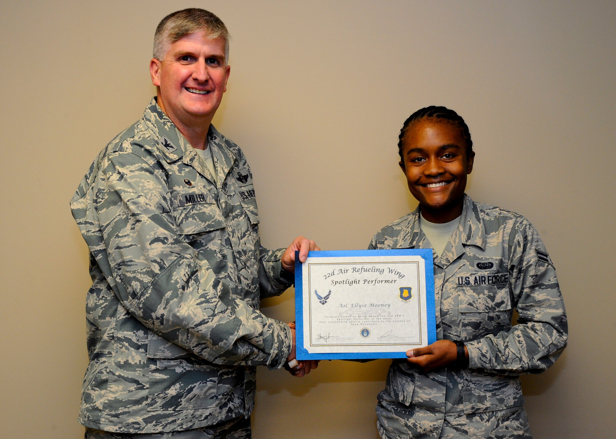 Airman 1st Class Ellyse Mooney, 22nd Communications Squadron information assurance technician, poses with Col. Albert Miller, 22nd Air Refueling Wing commander, Oct. 15, 2015, at McConnell Air Force Base, Kan. Mooney was received the spotlight performer for the week of Oct. 4 - 10. (U.S. Air Force photo/Senior Airman Victor J. Caputo)
