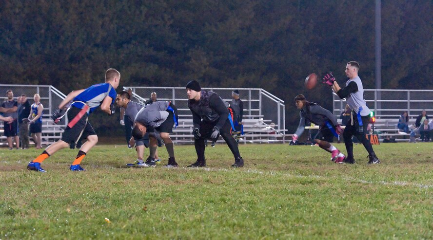 Kevin Fowler hikes the football to Joshua Orick, quarterback, as Travis Cabb, takes off running, all from 436th Logistics Readiness Squadron, during a running play against the 9th Airlift Squadron Nov. 4, 2015, on Dover Air Force Base, Del. The 436th LRS beat the 9th AS, 27-7, in a Dover AFB intramural flag football American Football Conference game. (U.S. Air Force photo/Roland Balik)
