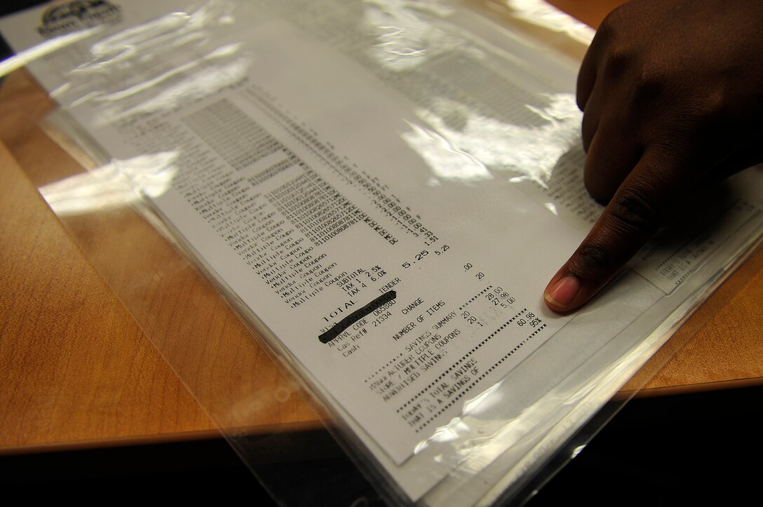 Calandria Tucker, Airman and Family Readiness Center community readiness consultant, looks at a receipt at a couponing class at Langley Air Force Base, Va., Nov. 6, 2015. A Langley patron was able to save 95 percent of their bill while using coupons during grocery shopping. (U.S. Air Force photo by Senior Airman Breonna Veal/Released)