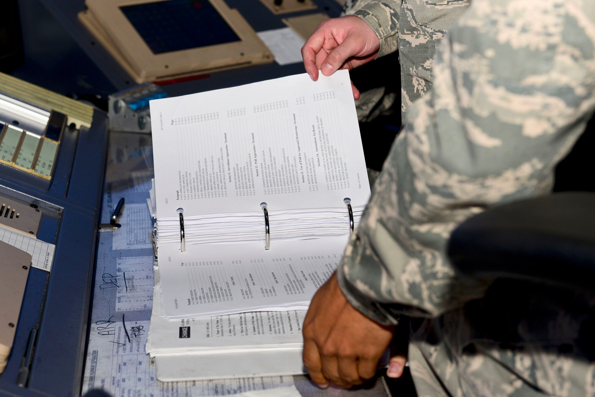 A U.S. Air Force Airman checks procedures in the air traffic control tower at Langley Air Force Base, Va., Nov. 4, 2015. Knowing the proper procedures and terms ensure fluid communication between the tower and pilots, in the air and on the ground. (U.S. Air Force photo by Airman 1st Class Derek Seifert/ Released)